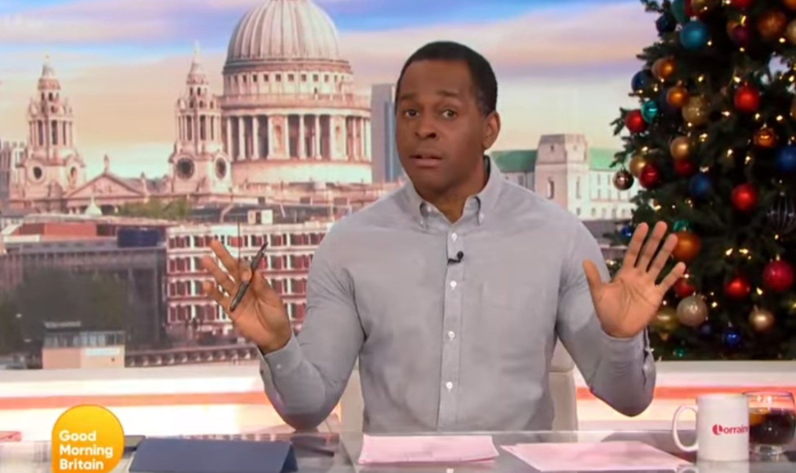 Andi Peters gesticulates with his hands while hosting GMB