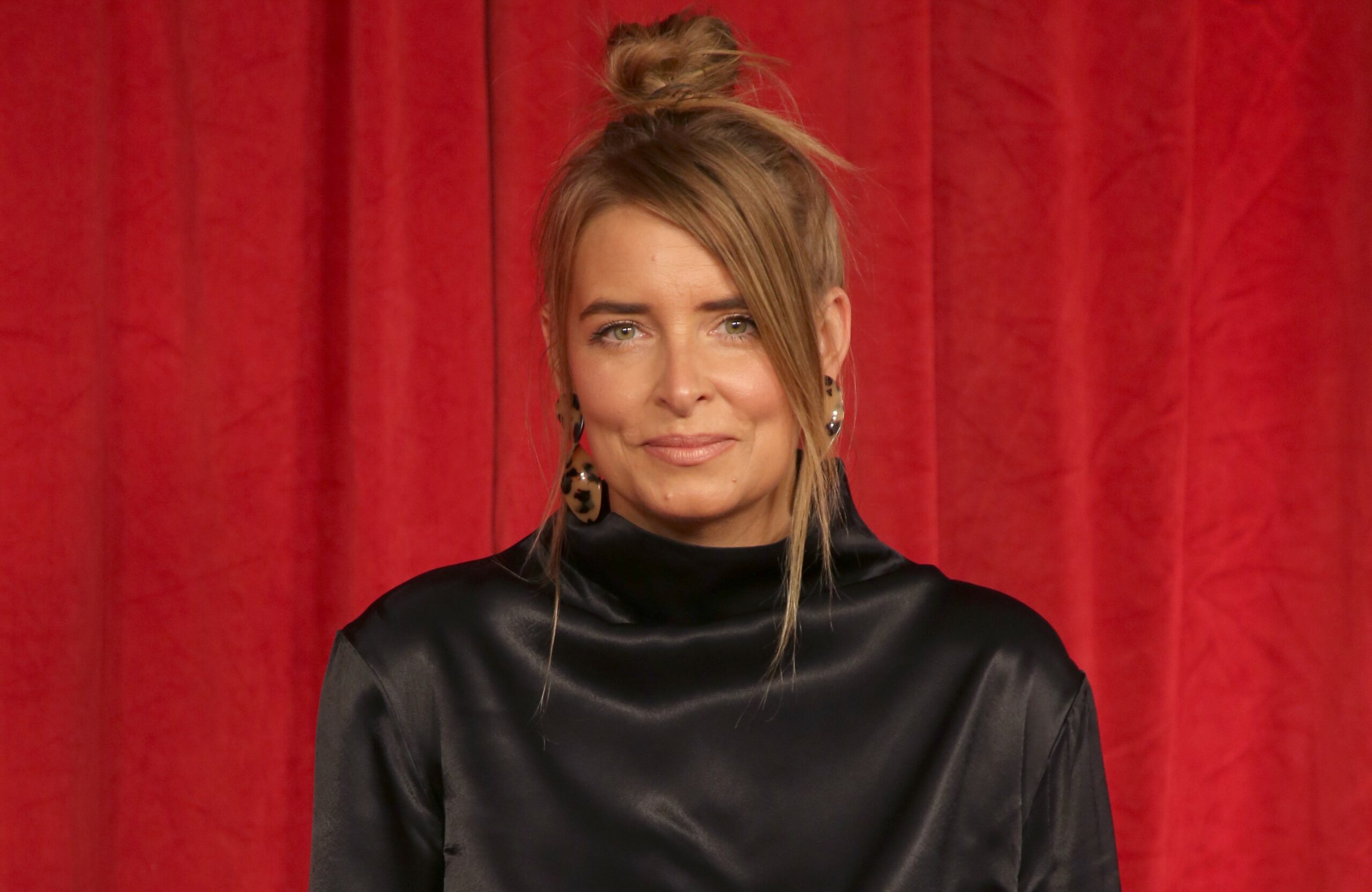 Emma Atkins poses on the red carpet at the British Soap Awards with her hair up and a muted smile
