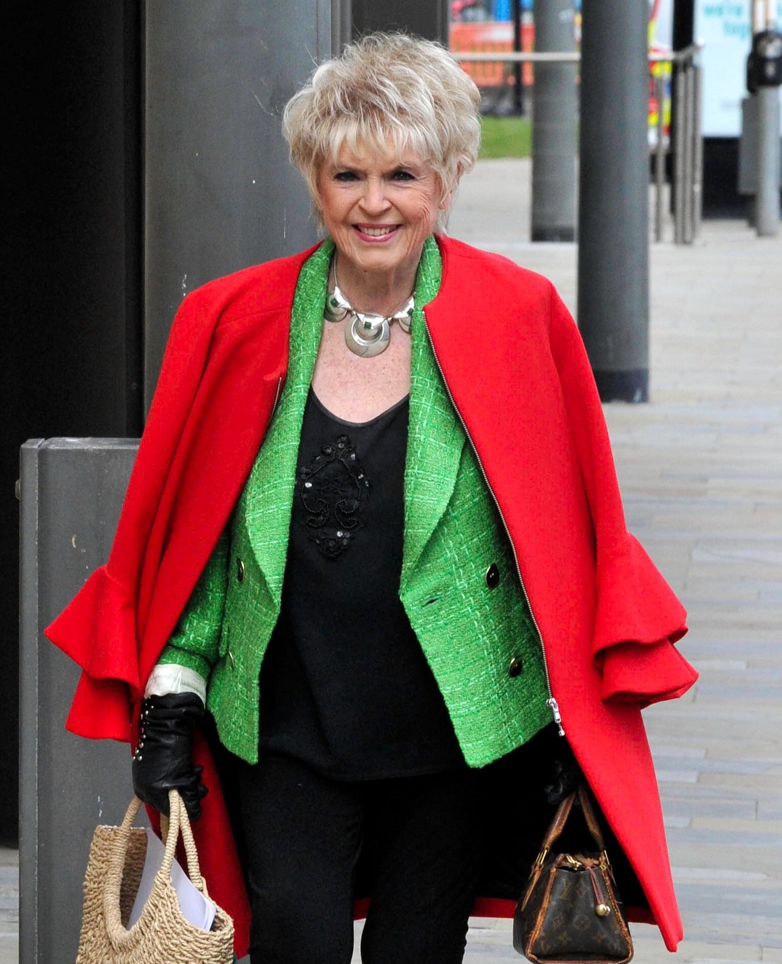 Gloria Hunniford grins as she shops in a red coat