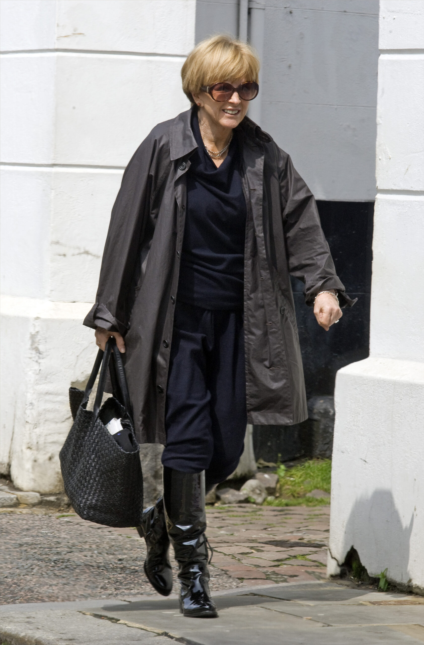 Anne Robinson walking down the street dressed in dark clothes