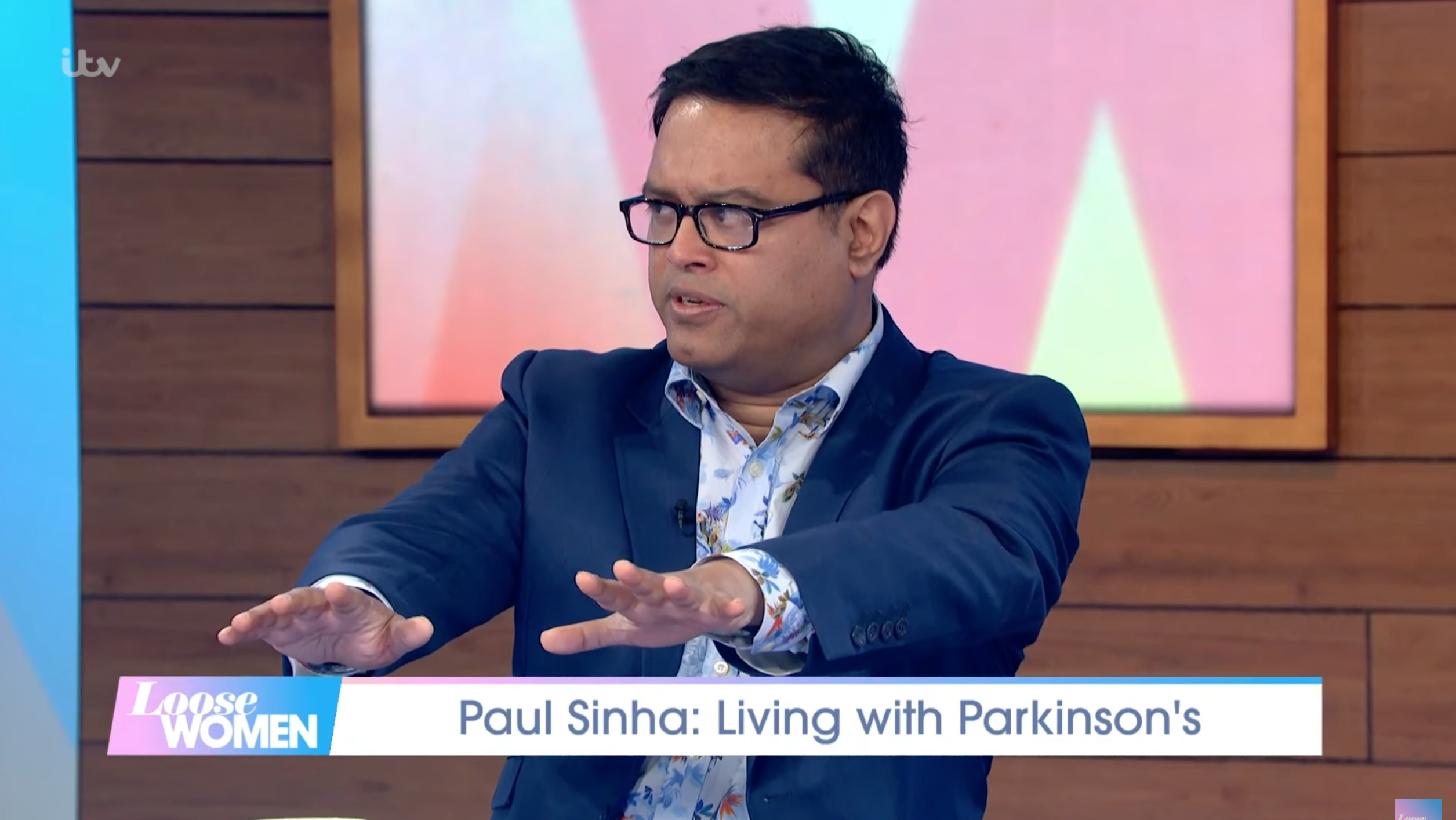 Paul Sinha wearing a blue suit on Loose Women holding out his hands