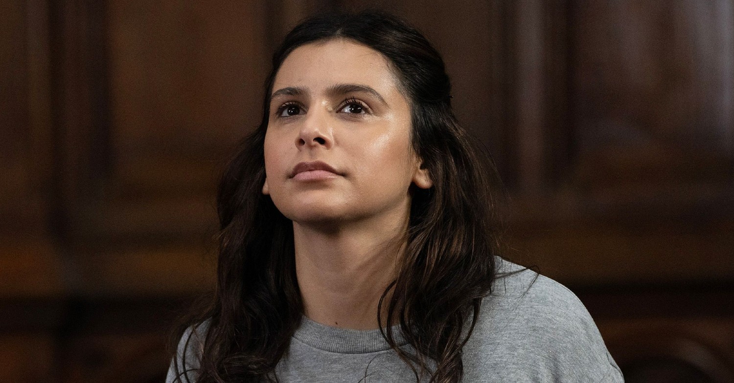 Meena looking up and smirking in the court dock in Emmerdale (Credit: ITV)