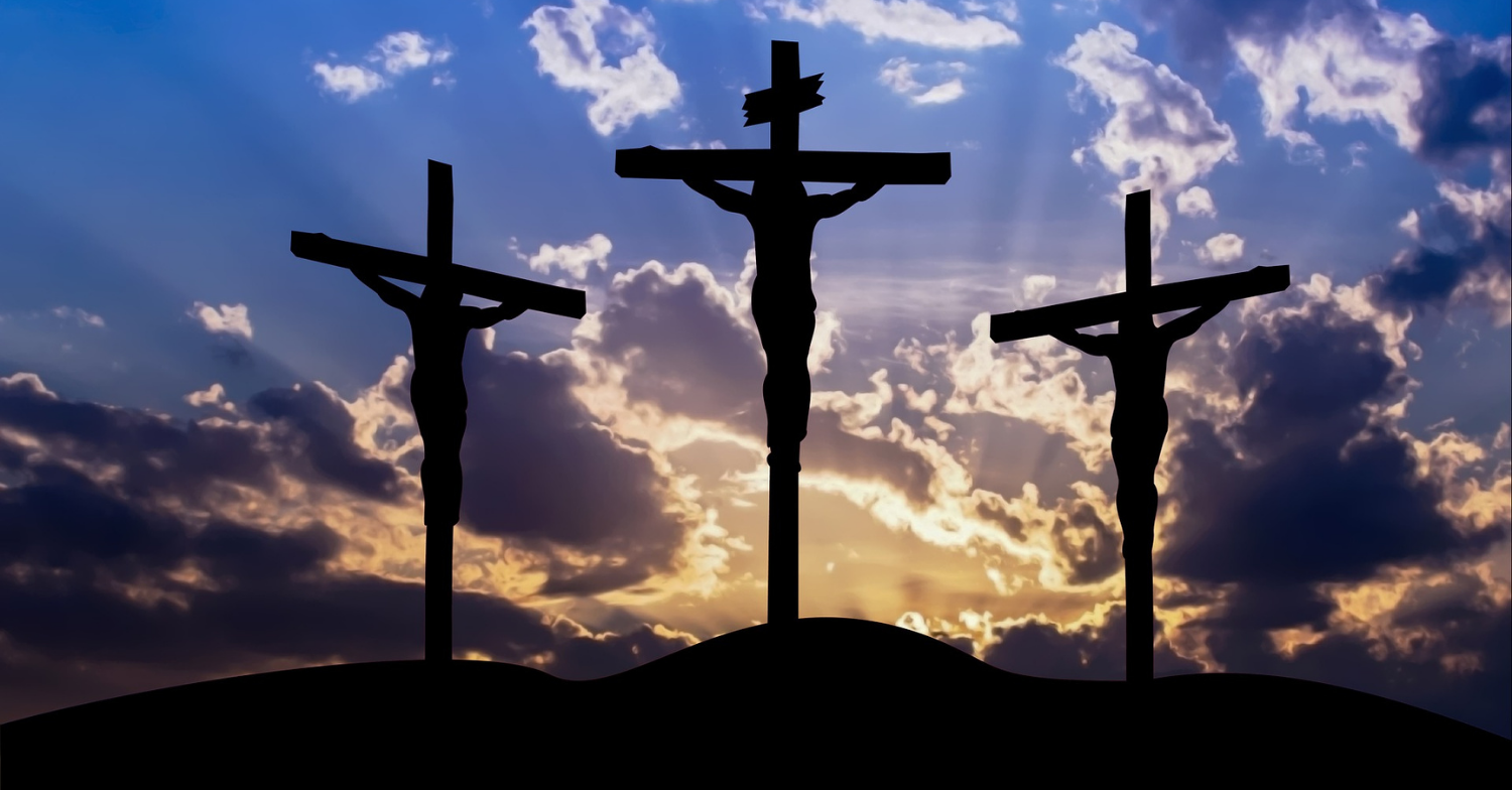 Three crucifixes in front of a sunset