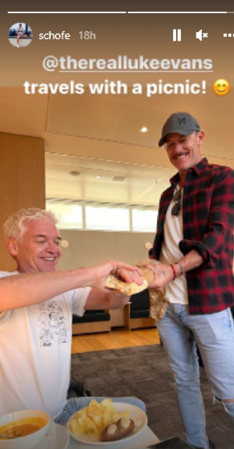 Phillip Schofield takes piece of bread from Luke Evans during skiing holiday
