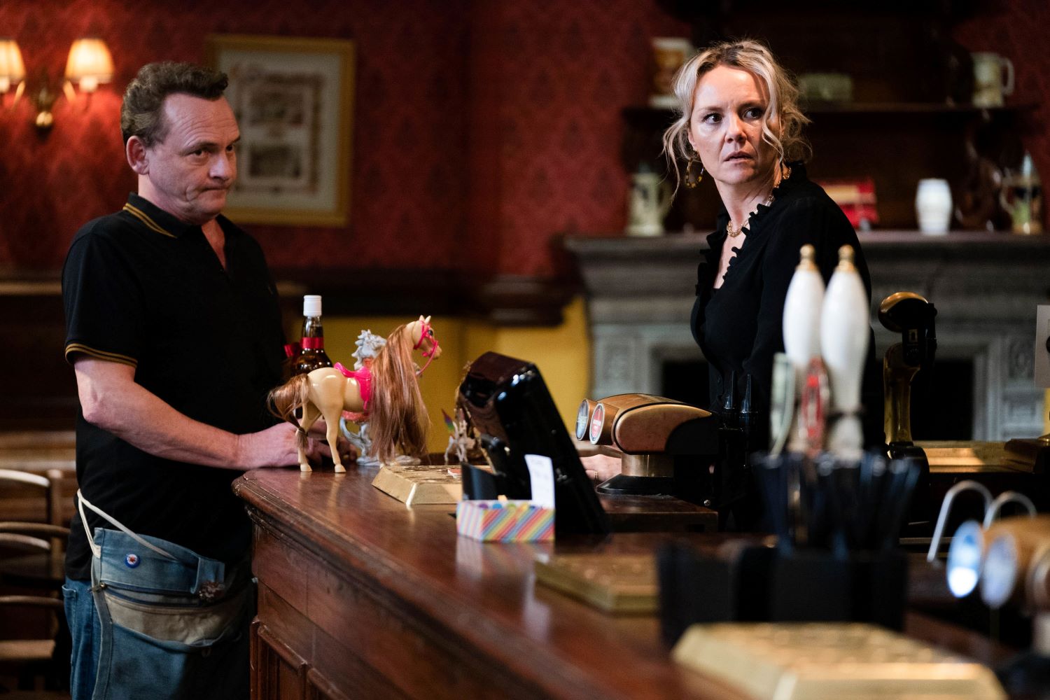 EastEnders Billy looks resigned as Janine looks shocked in The Queen Vic