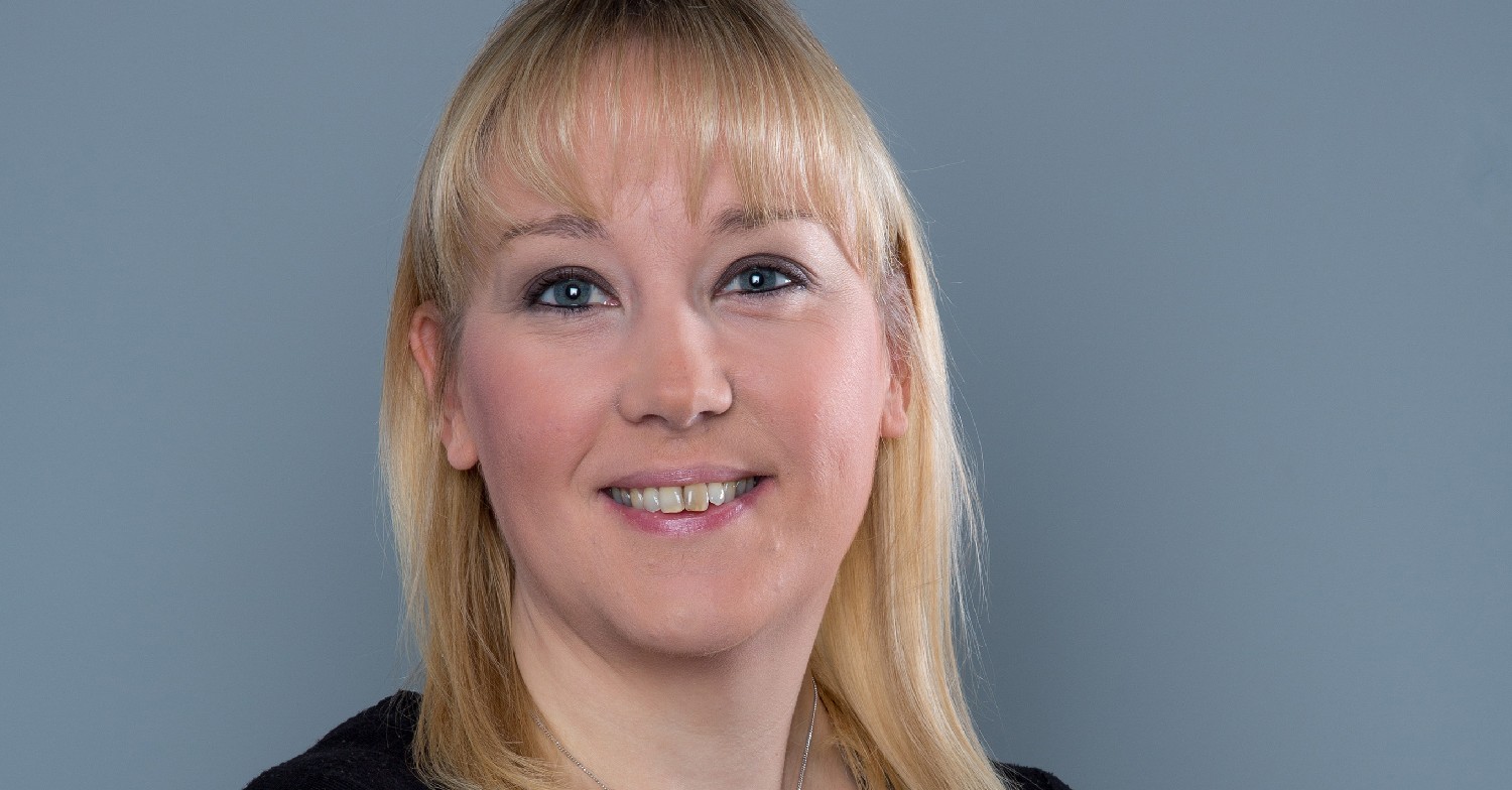 Emmerdale boss Laura Shaw smiling against a grey backgound