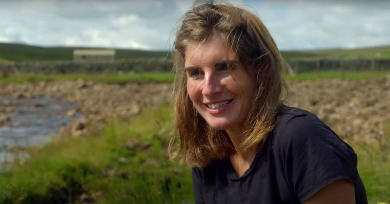 Amanda Owen sitting in a field