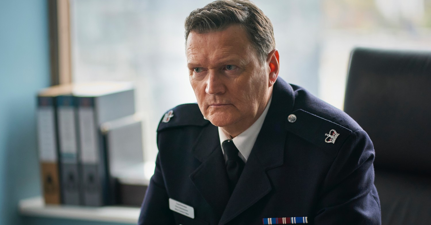 Ian Puleston-Davies in police uniform sat at desk 