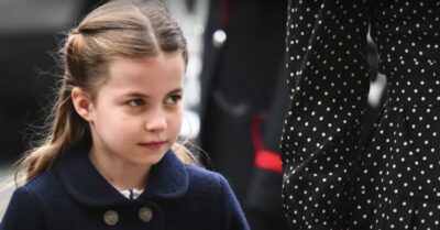 Princess Charlotte smiling while holding her mum Kate Middleton's hand