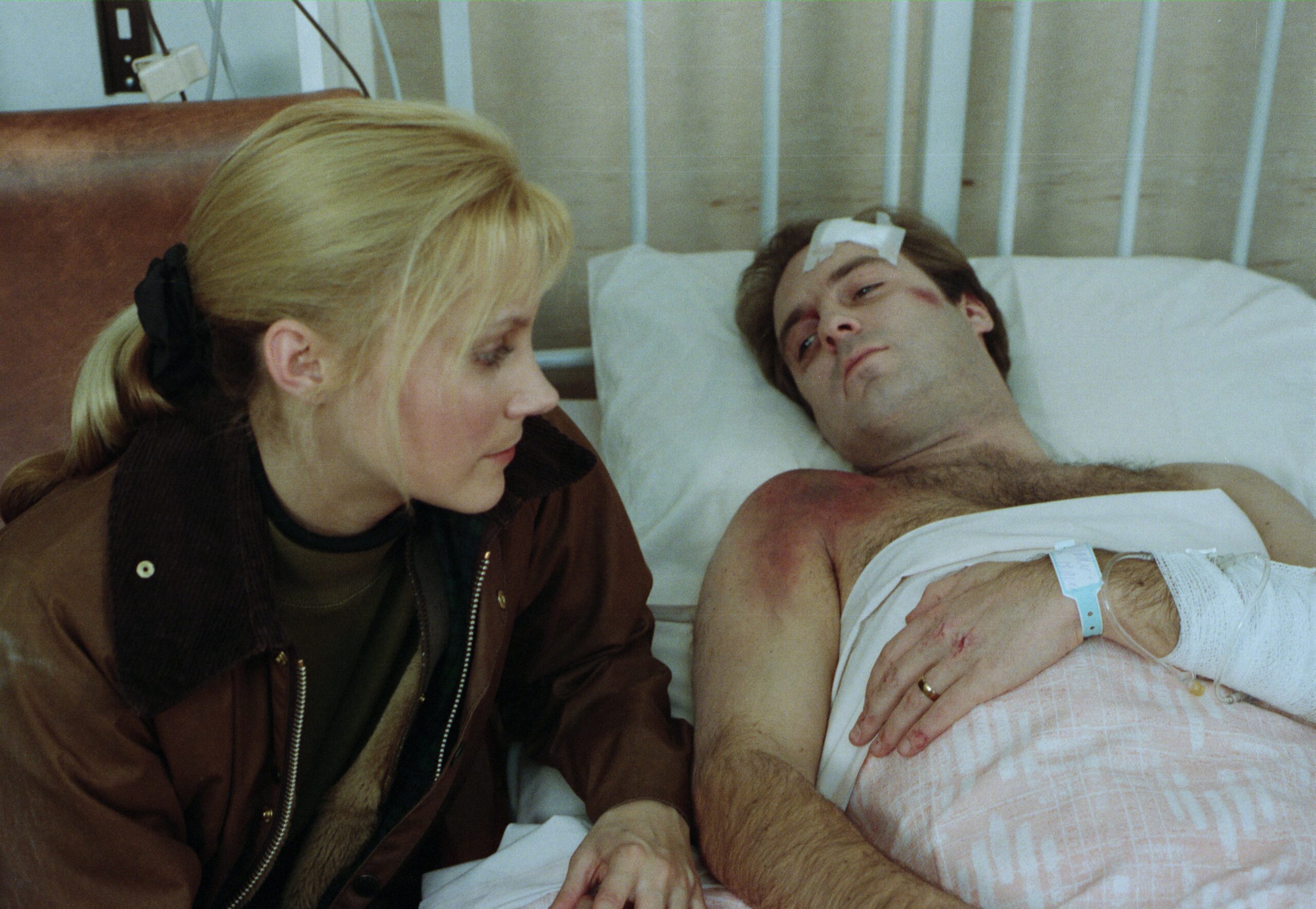 Kathy Tate sits by the hospital bed of her husband Chris, after the Beckindale plane crash