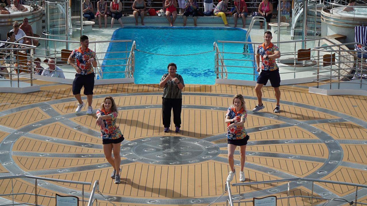 Susan Calman performs a song at the end of her cruising show with ship staff