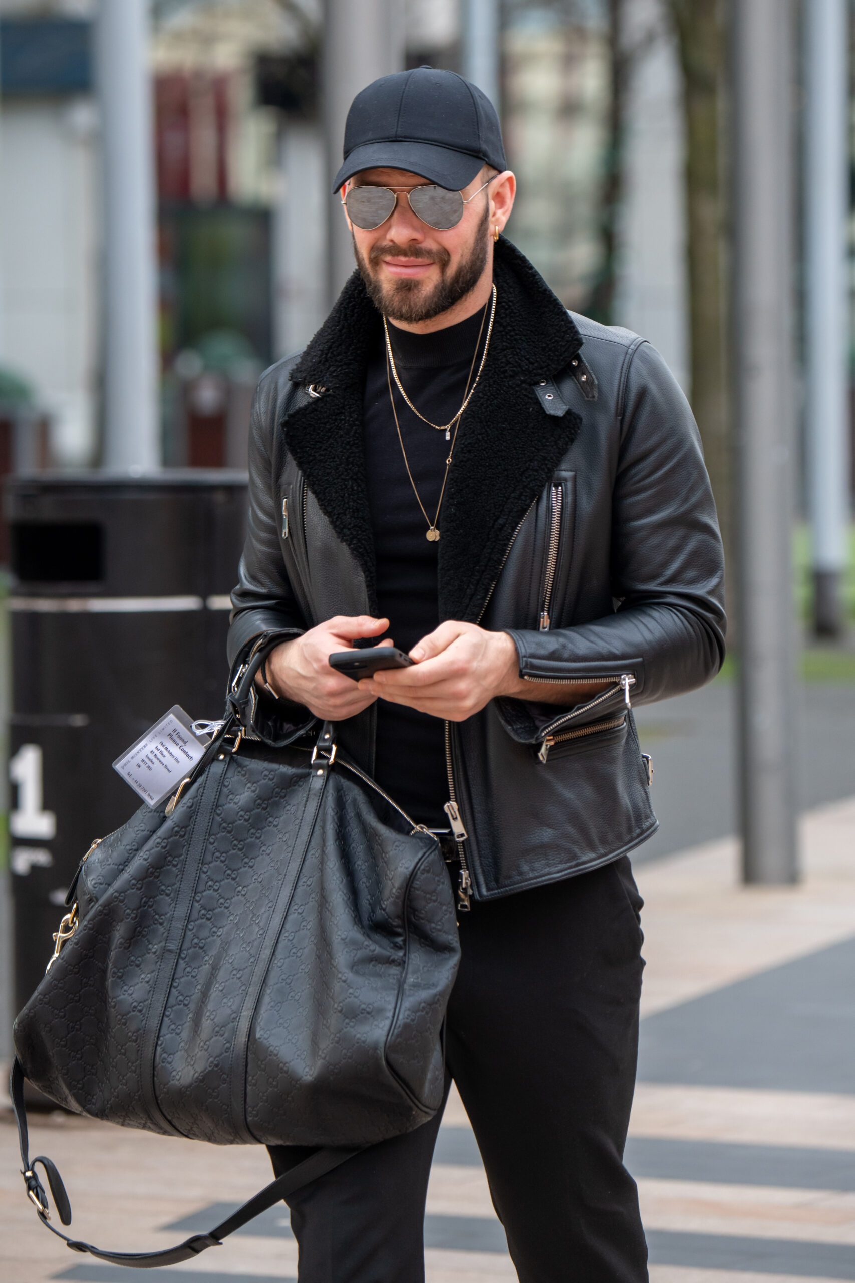 John Whaite smiling wearing shades and jacket as he prepares for Strictly tour