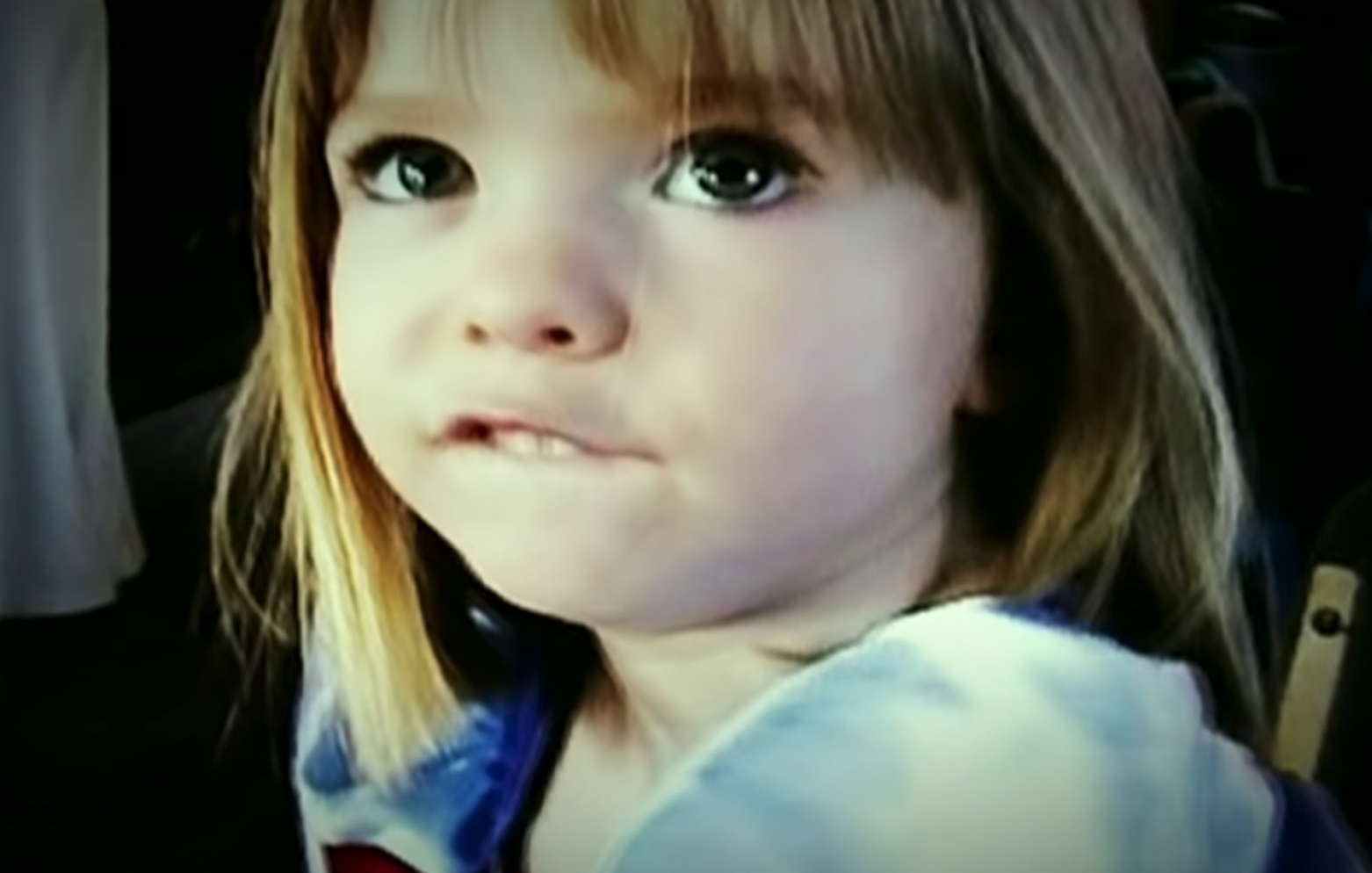 Madeleine McCann biting her lip wearing a Disney dress