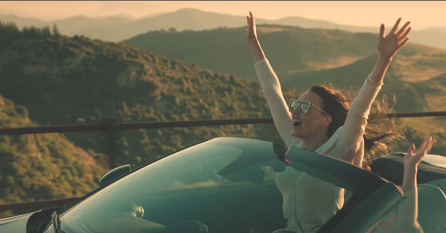 365 Days: This Day woman in a convertible with her arms in the air