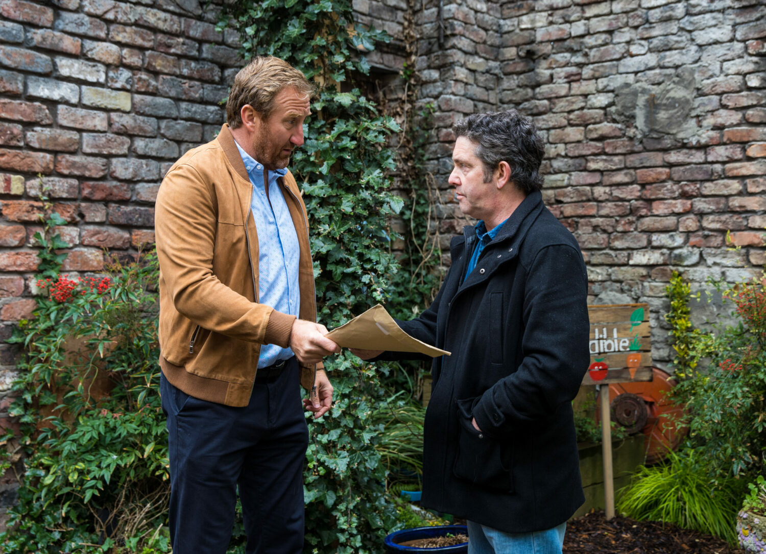 Corrie Phill gives an envelope to a mystery man