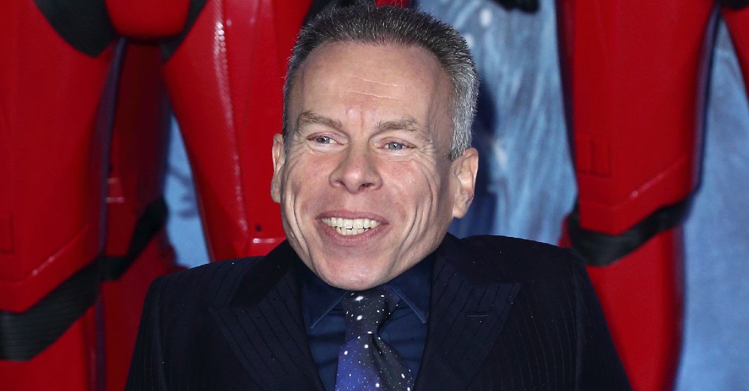 Warwick Davis in suit at movie premiere