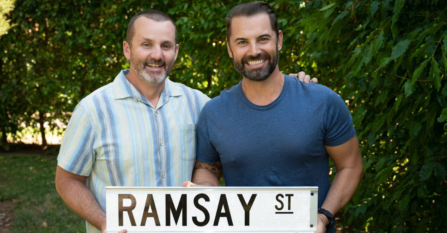 Ryan Moloney and Dan MacPherson hold a Ramsay Street sign