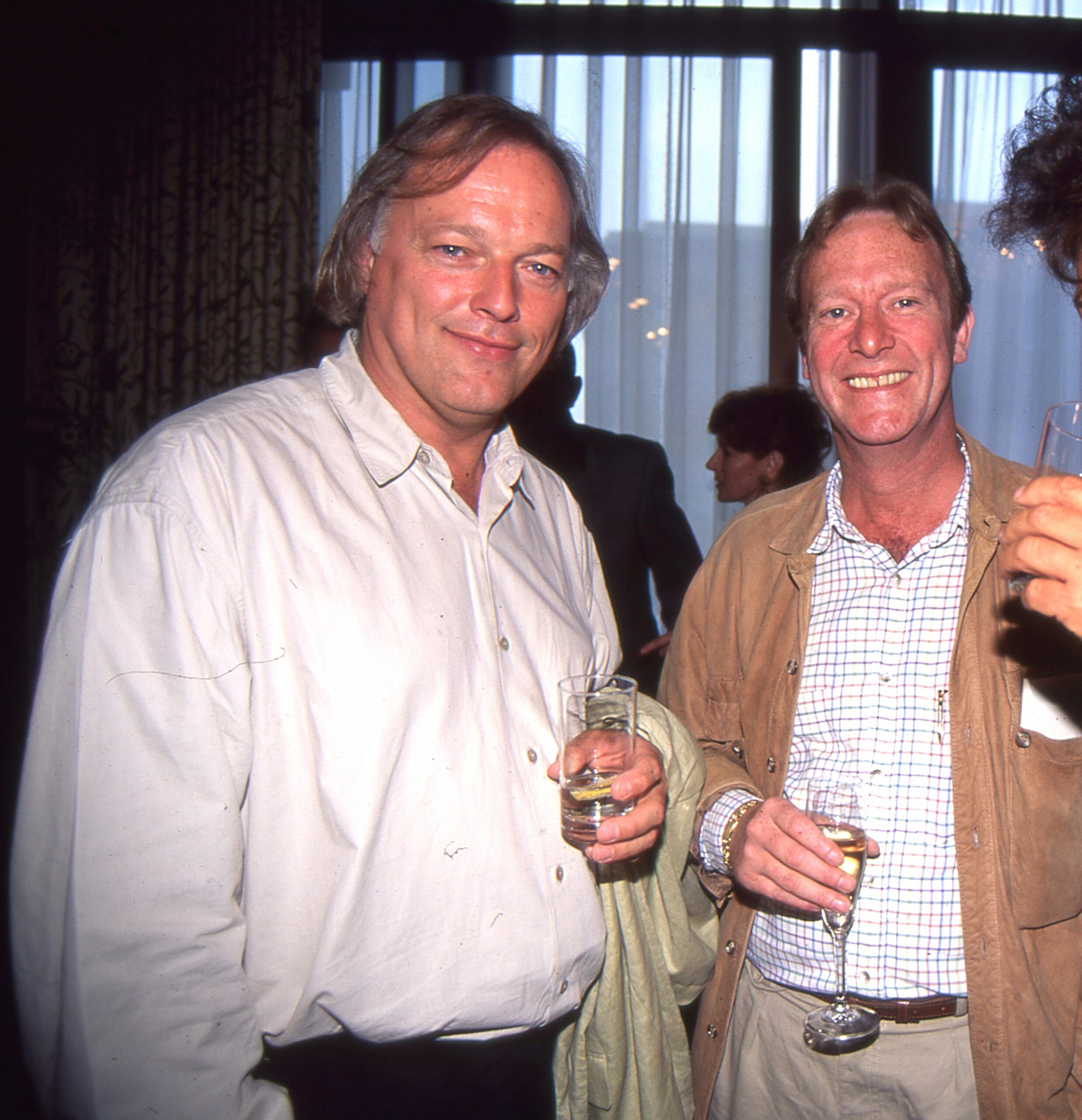Dennis Waterman smiling at a party with a friend