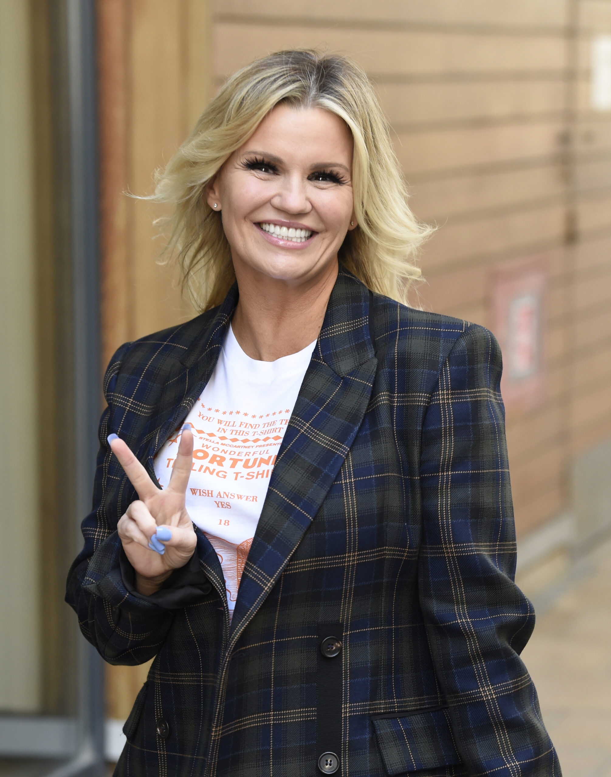 Kerry Katona smiling and flashing the peace sign