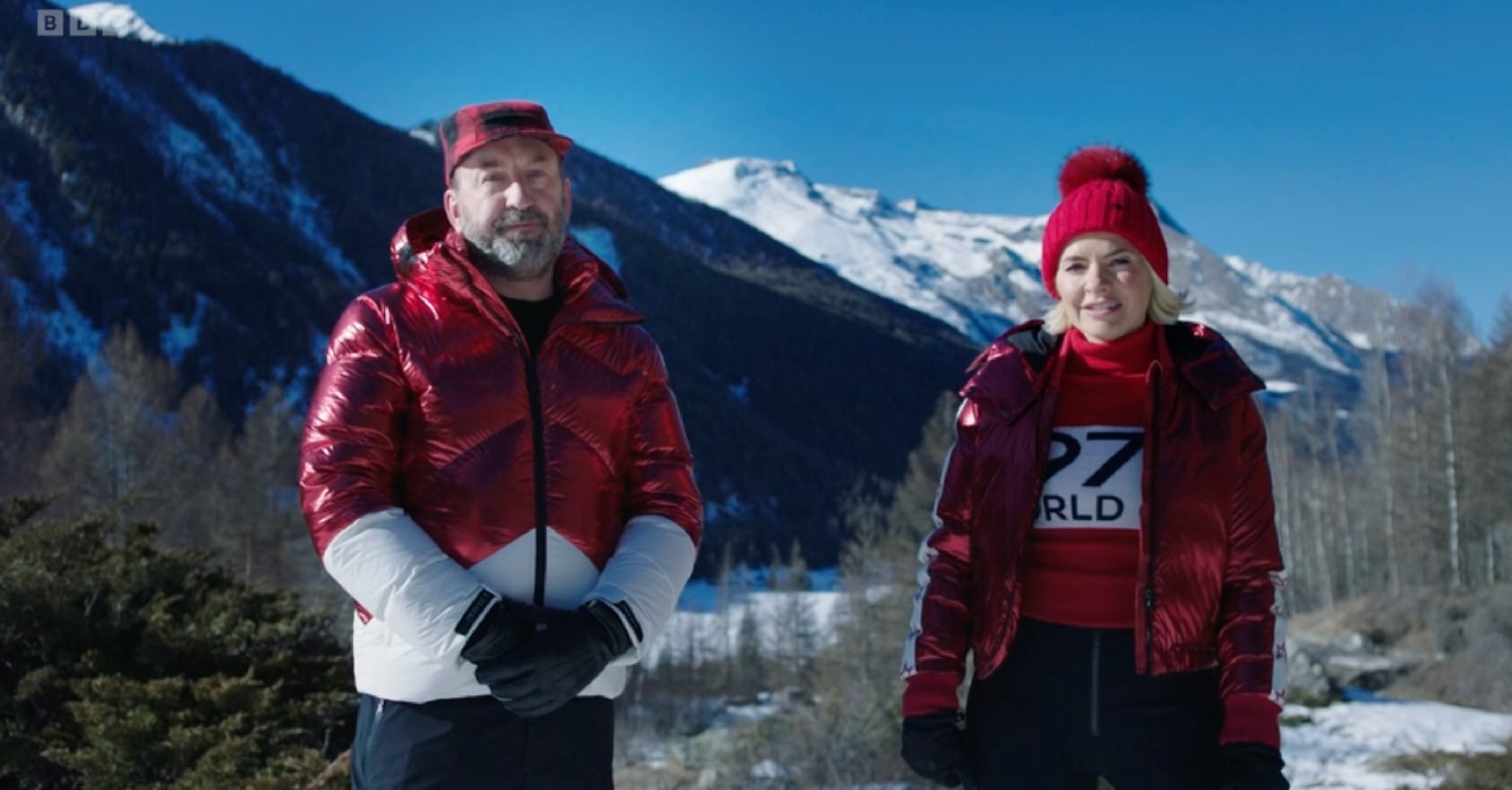 Holly Willoughby and Lee Mack in winter clothes, with snowy mountains in the background, addressing the camera during Freeze the Fear