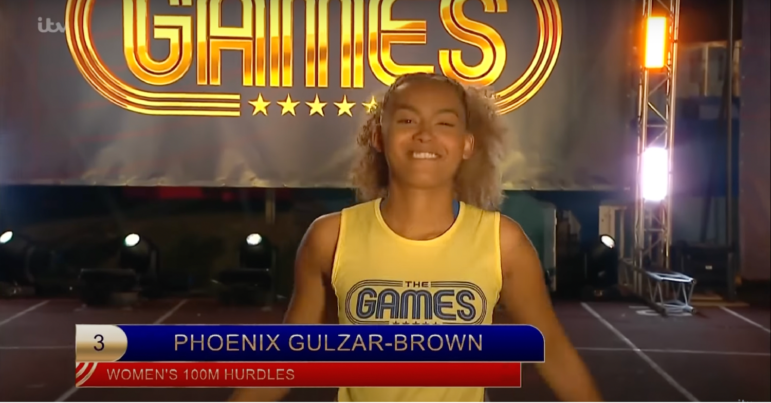 Phoenix Gulzar in a yellow vest, smiling for the camera on an athletics track 