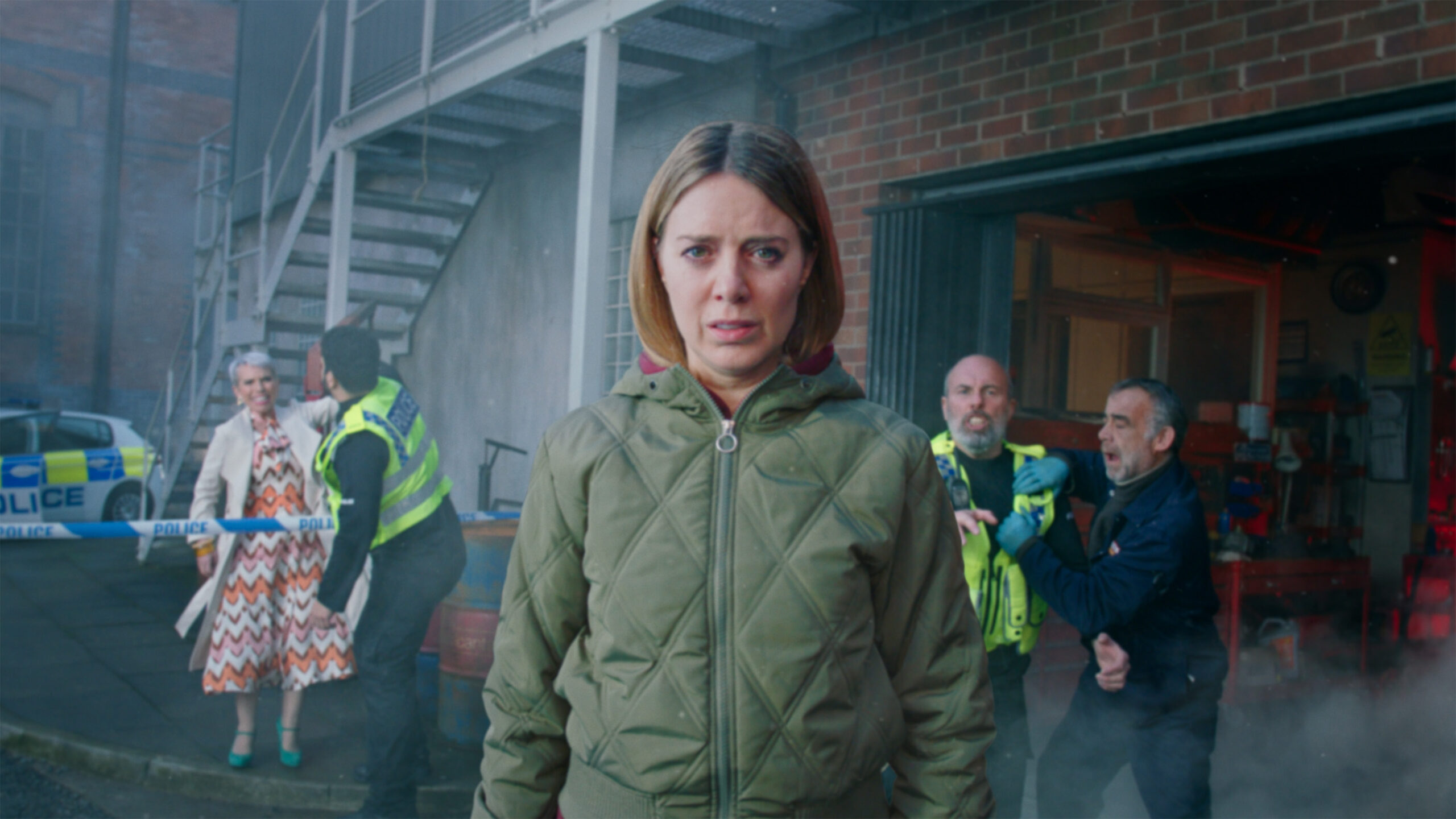 Coronation Street Abi looking into the camera looking worried with police in the background