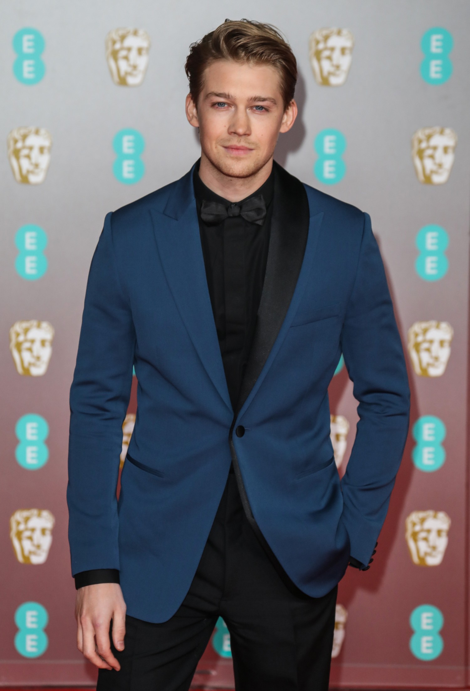 Joe Alwyn posing in a blue jacket at the BAFTAS