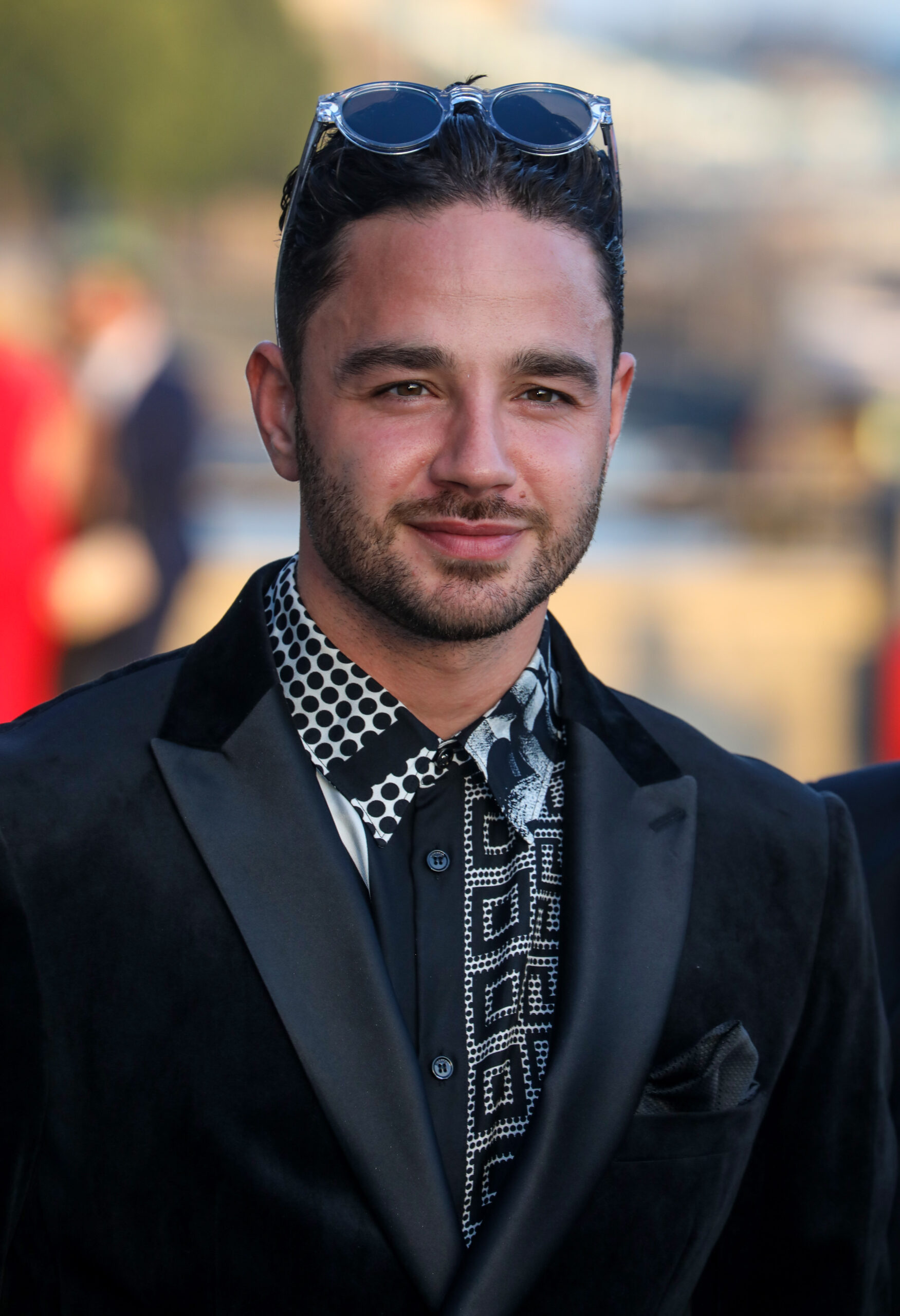 Adam Thomas smiling on the red carpet