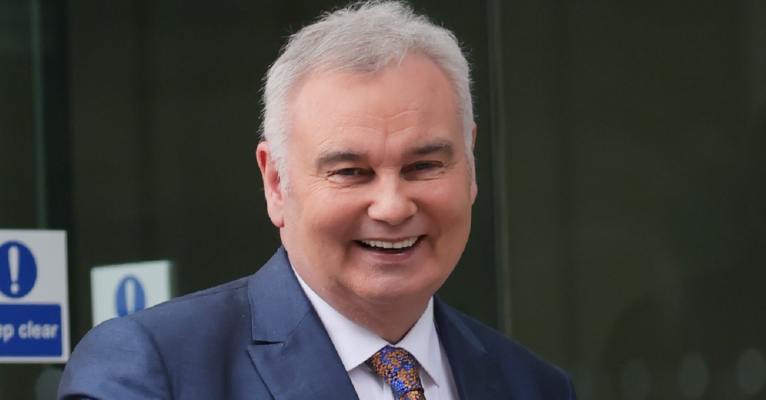 Eamonn Holmes smiles at cameras in blue suit