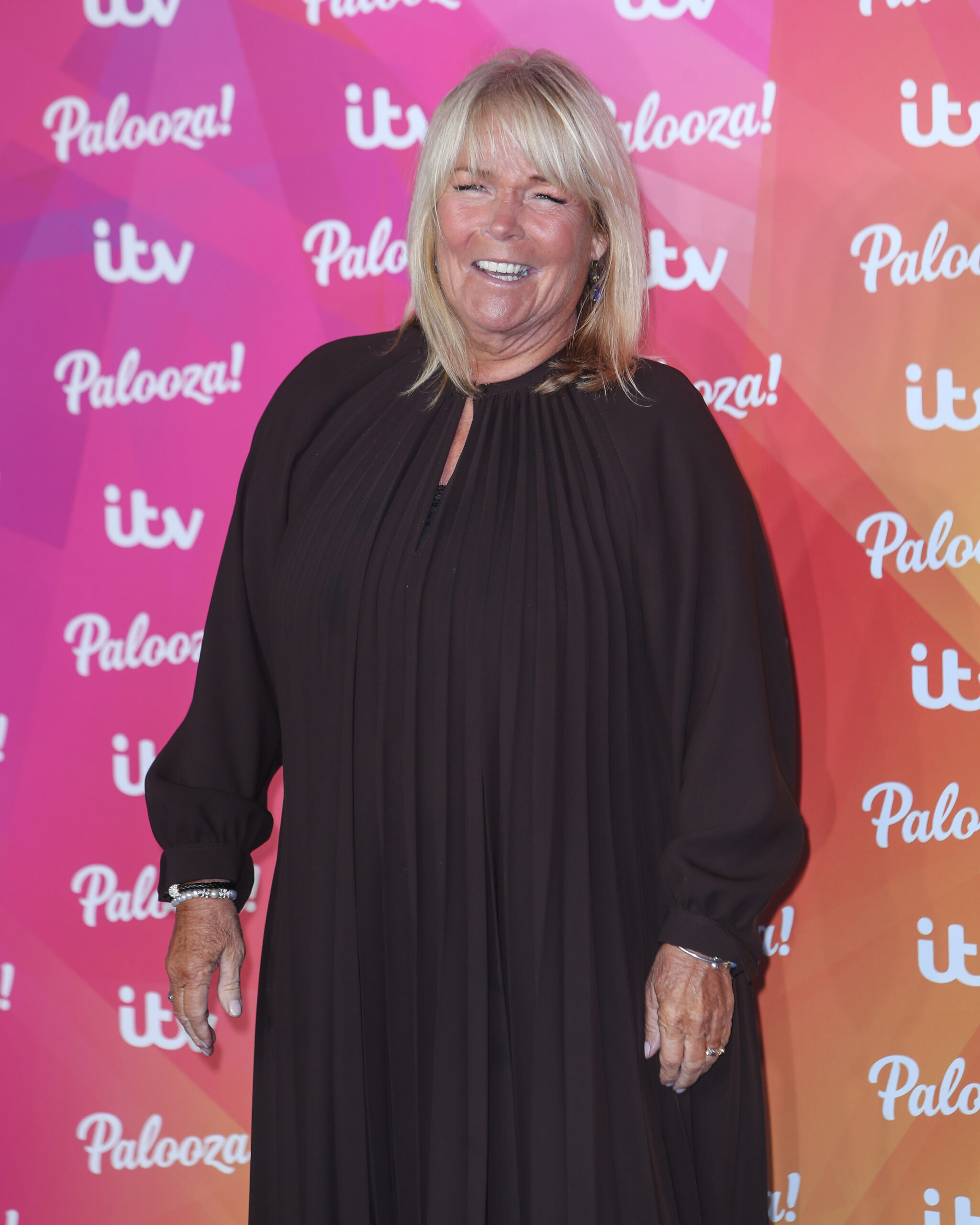 Linda Robson smiling on the red carpet wearing black