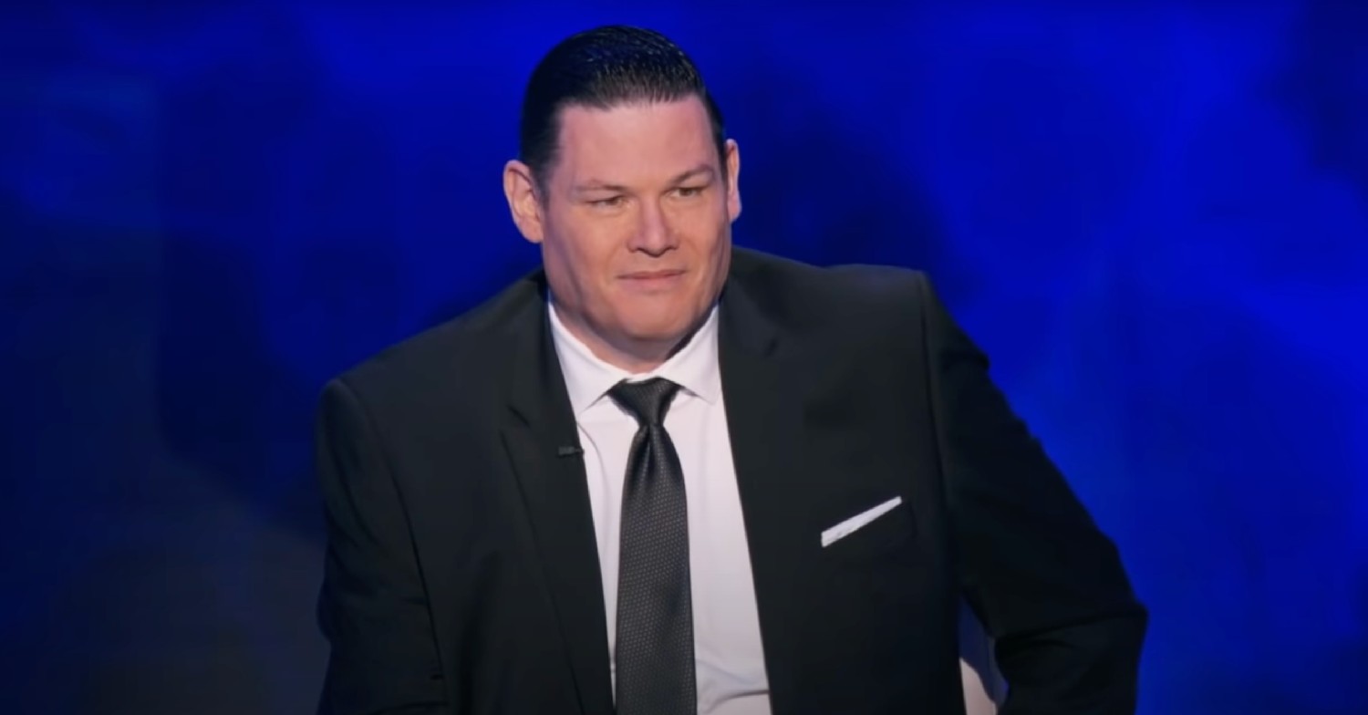 Beat the Chasers star Mark Labbett wearing a suit, smiling