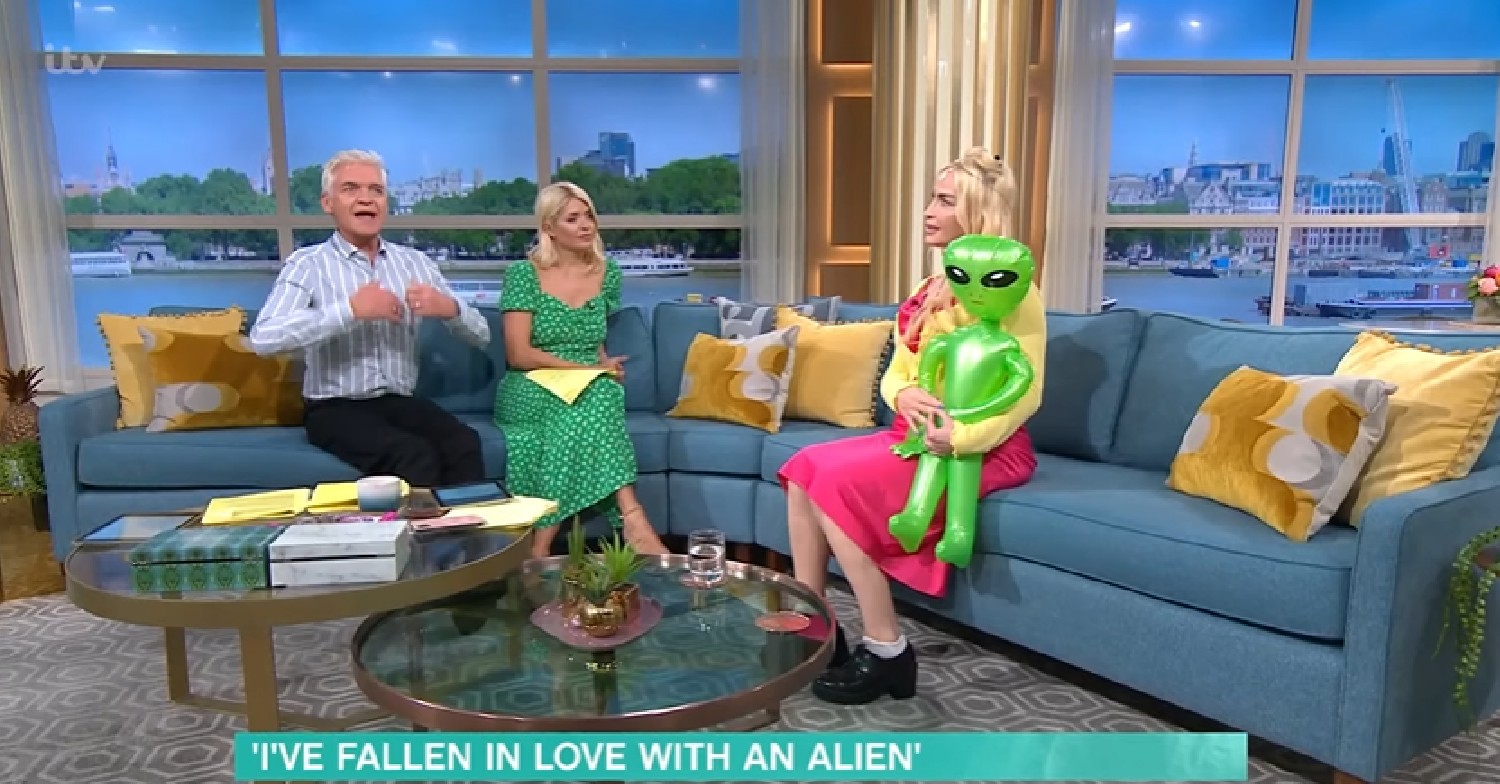 Phillip Schofield and Holly Willoughby speaking with This Morning guest who's holding an inflatable alien