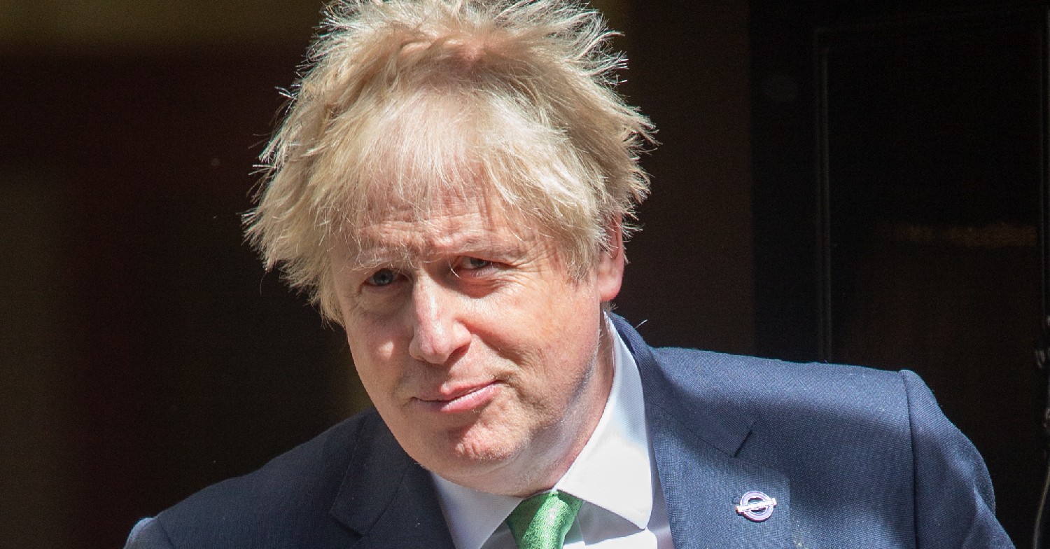 Boris Johnson grinning in blue suit