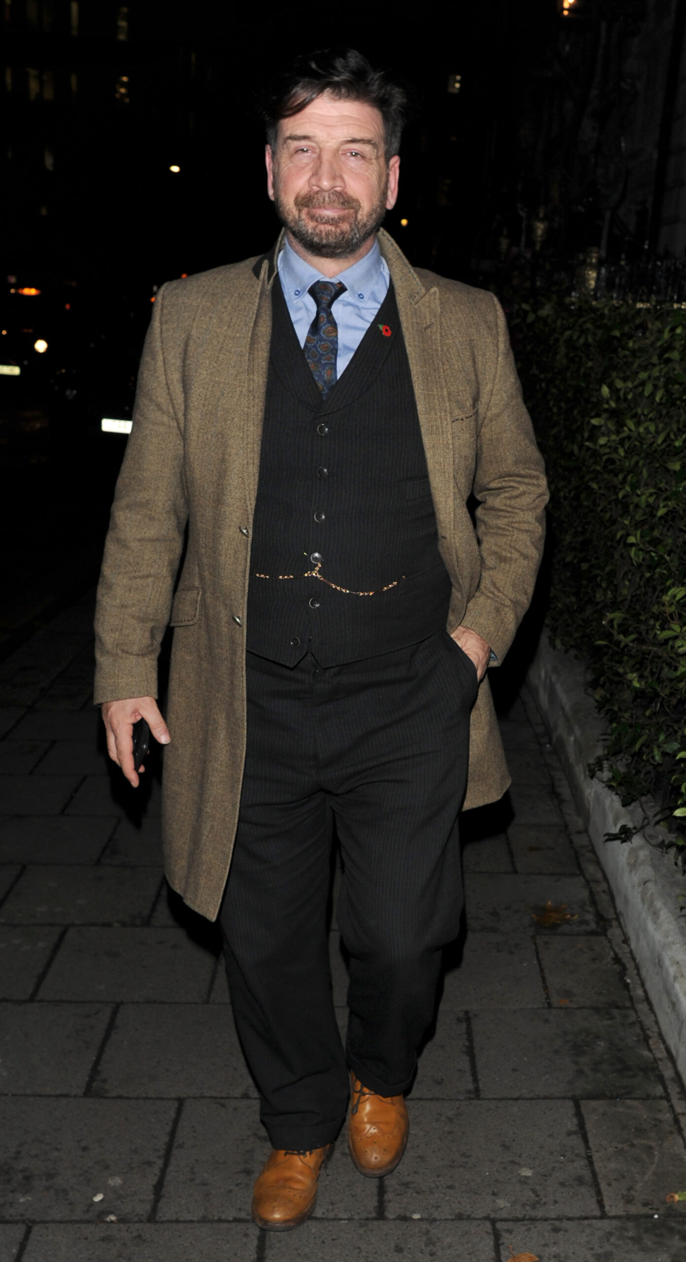 Nick Knowles smiles as he strolls down the street dressed in a suit (Credit: SplashNews)