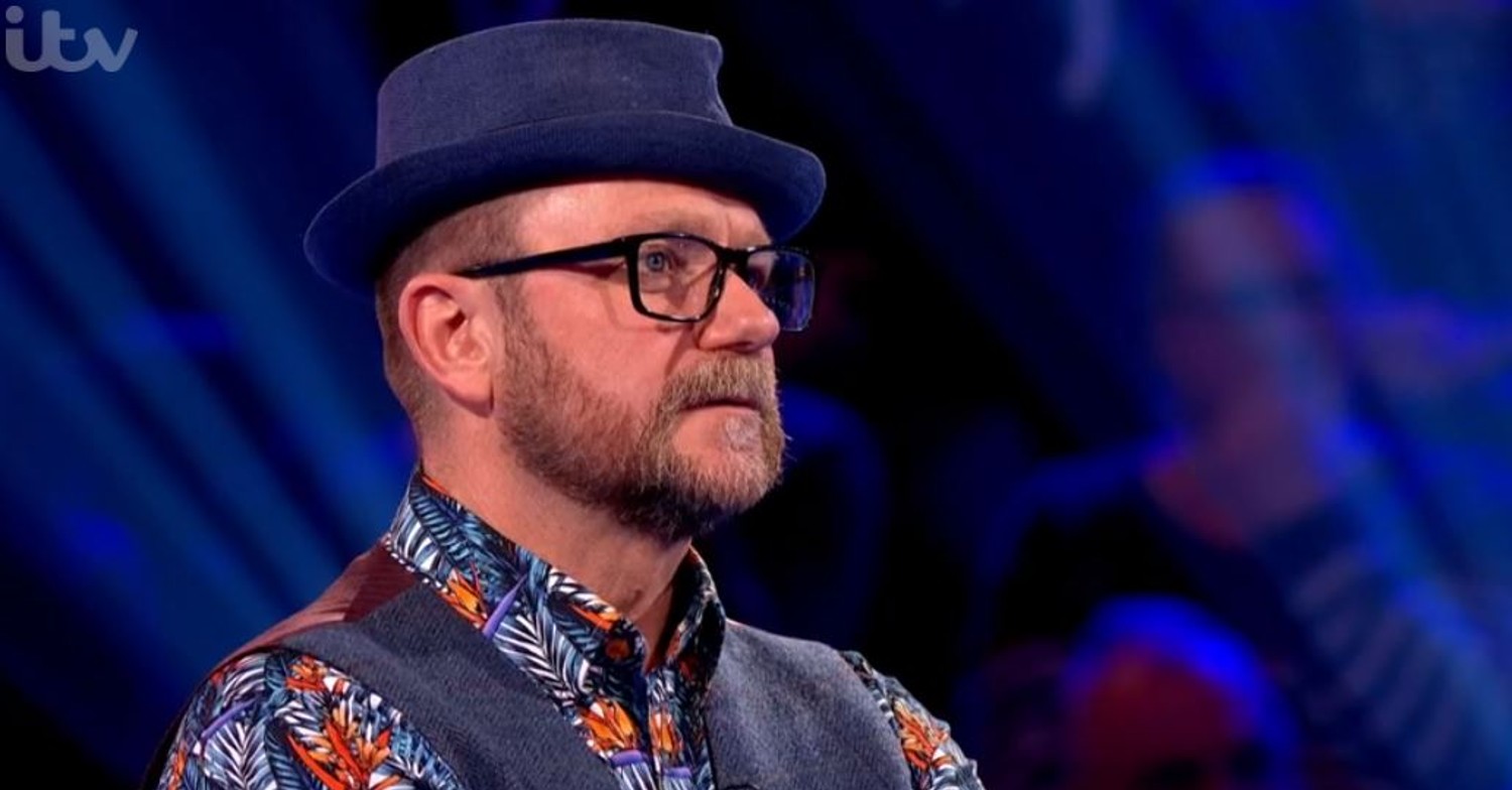 Frankie on Beat the Chasers, wearing a hat, looking concerned