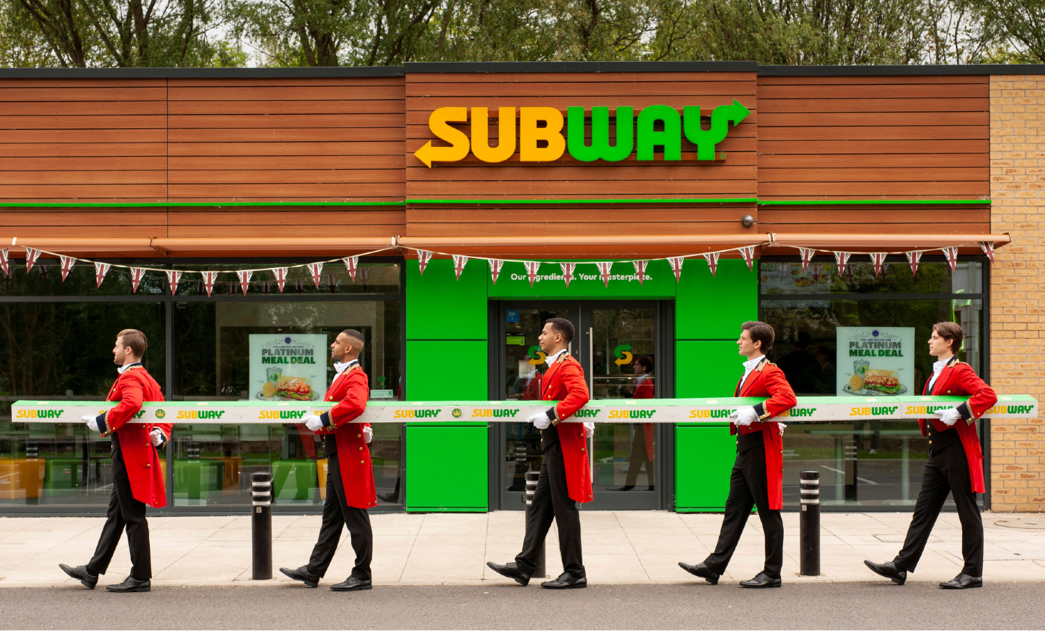 Subway's seven-meter sub being carried by five men in suits