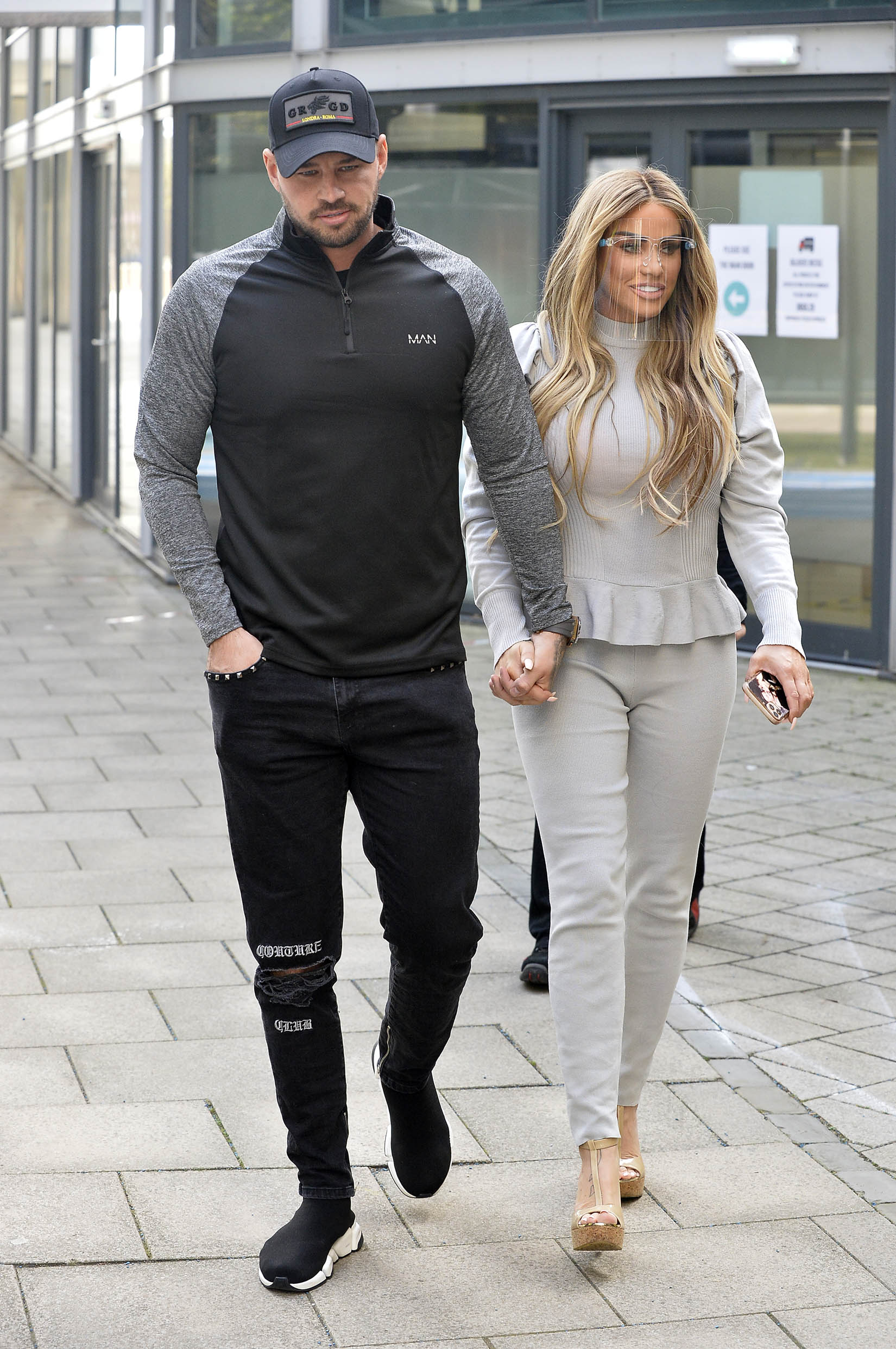 Carl Woods and Katie Price holding hands in the street
