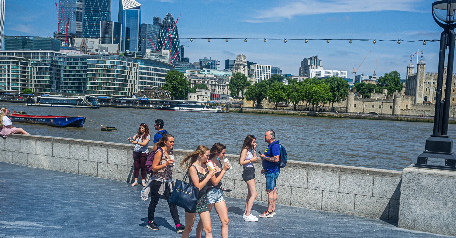 People walking along London embankment during heatwave UK weather