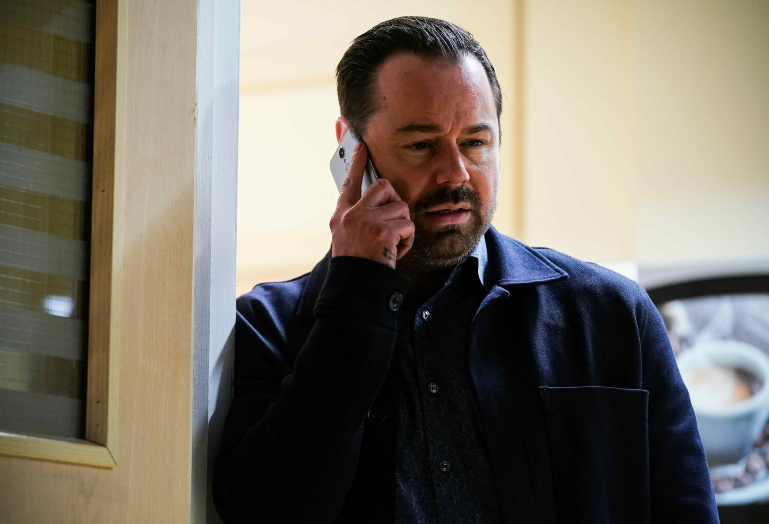 EastEnders Mick looks upset while on the phone