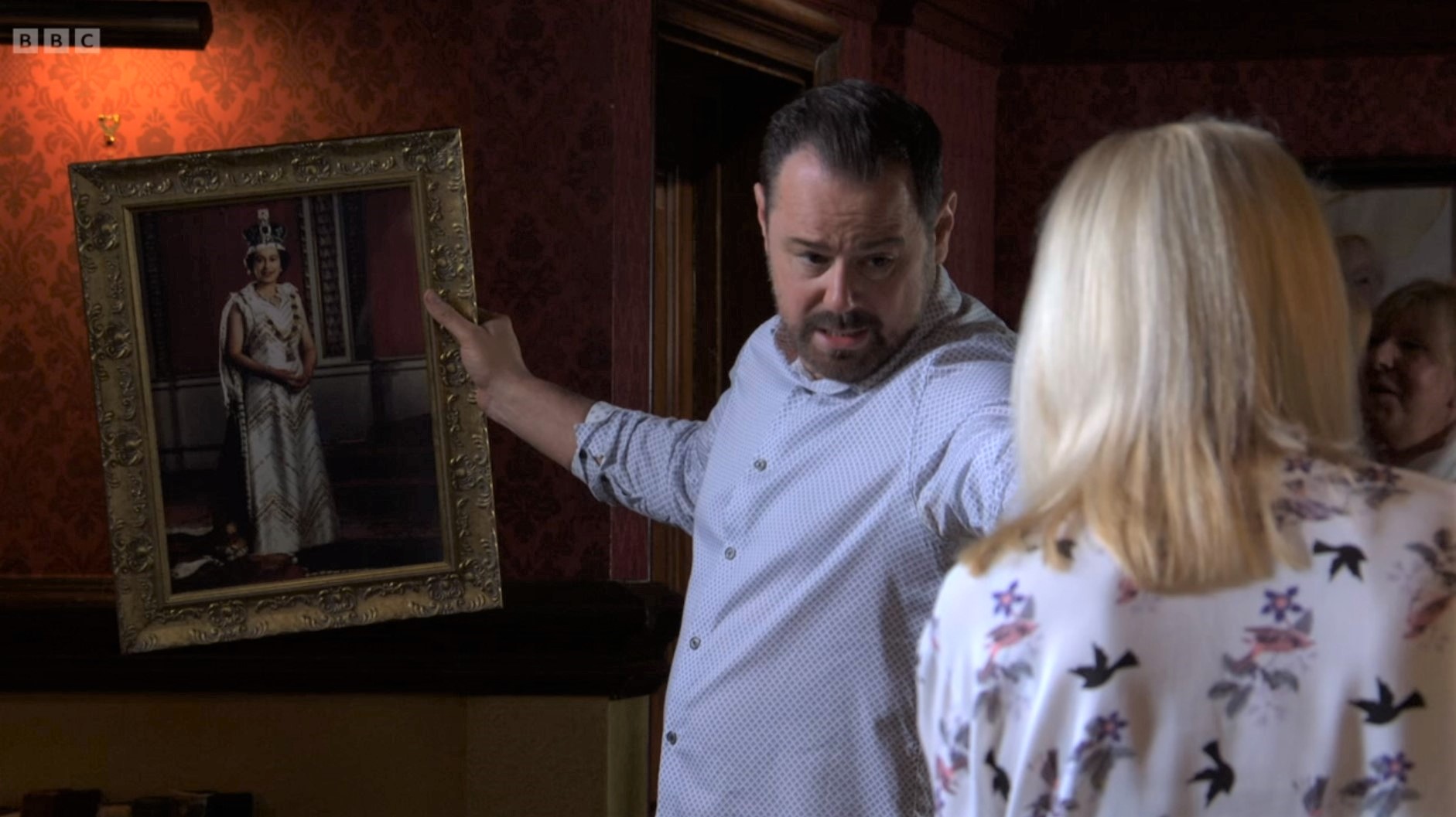Mick Carter holds a picture of the Queen as he talks to Kathy Beale
