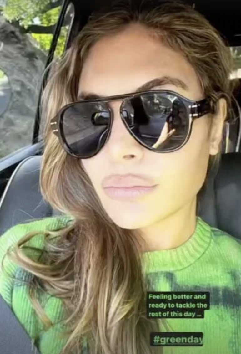 Ayda Field, Robbie Williams' wife, wearing sunglasses and a green jumper in the car