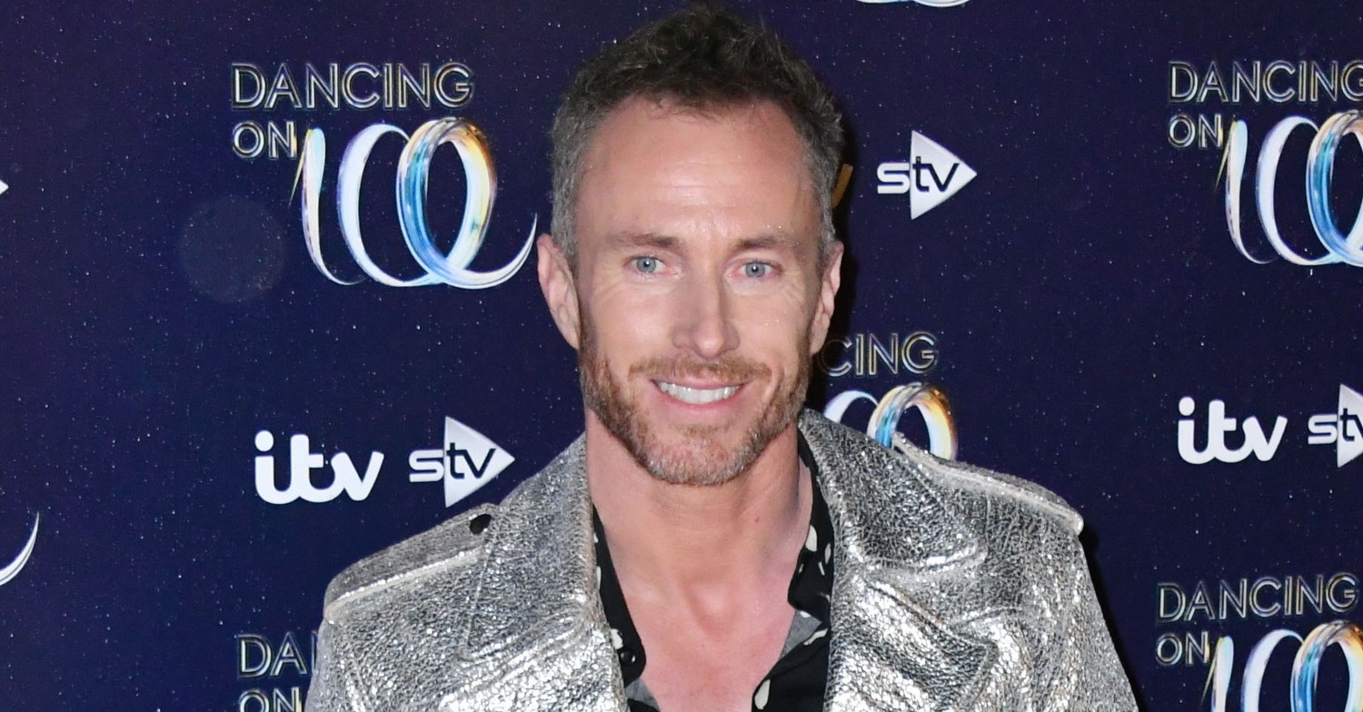James Jordan, wearing a silver jacket, smiling on a red carpet event