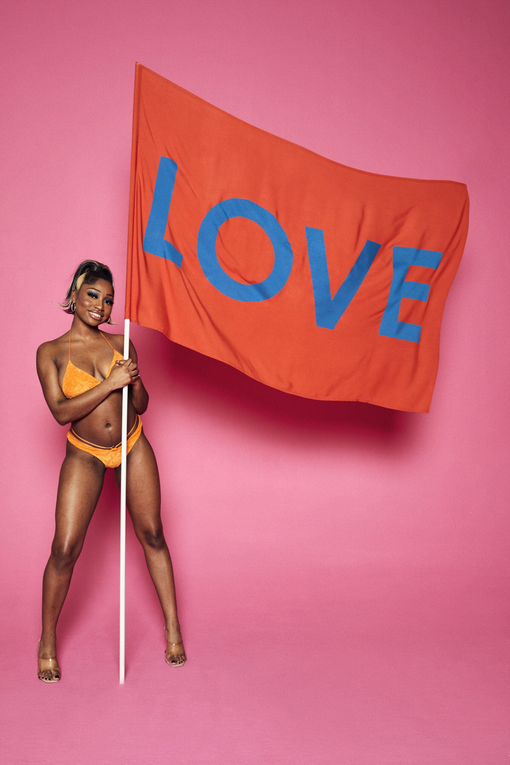 Love Island cast member holding a flag