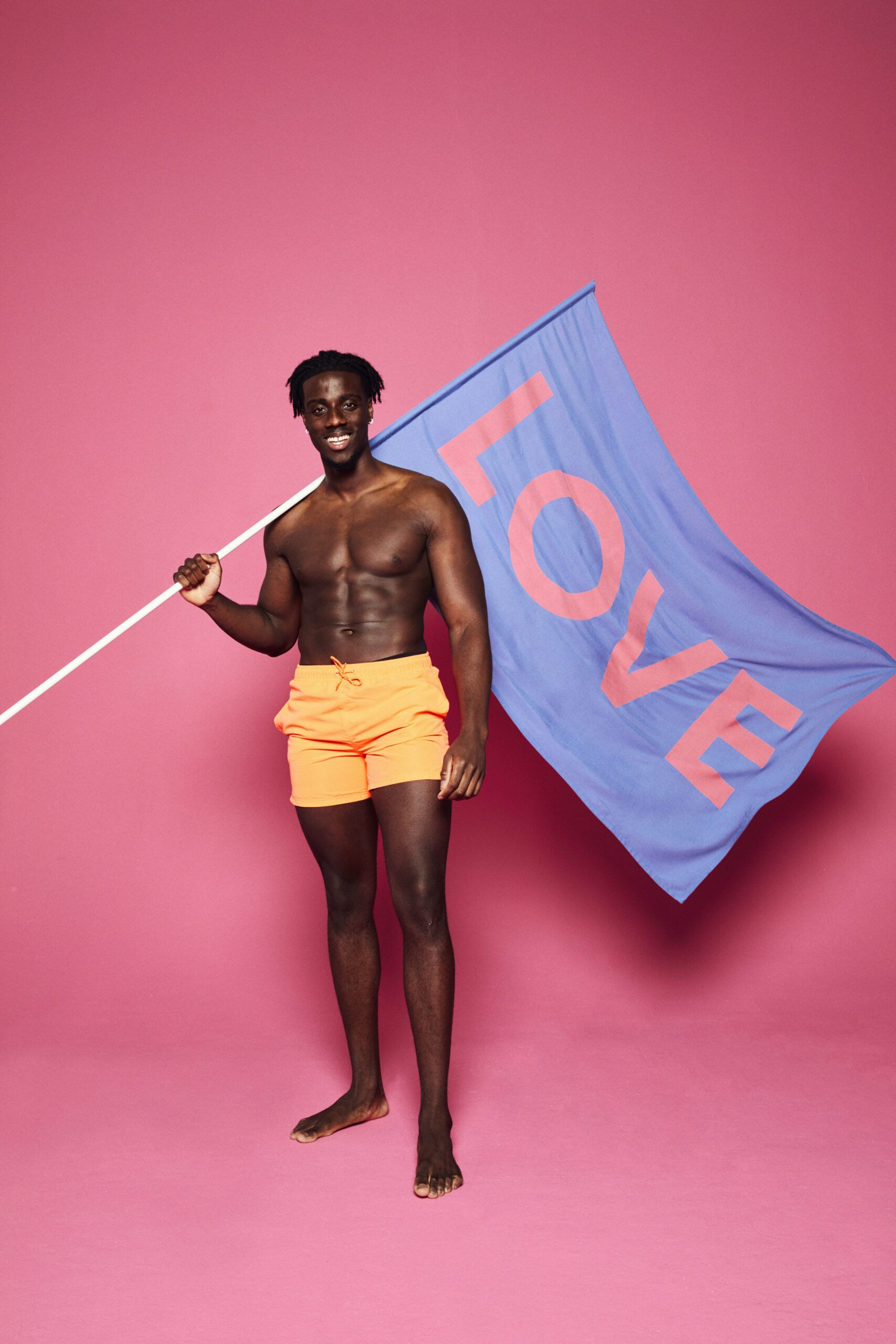 Love Island contestant in swimwear holding a flag