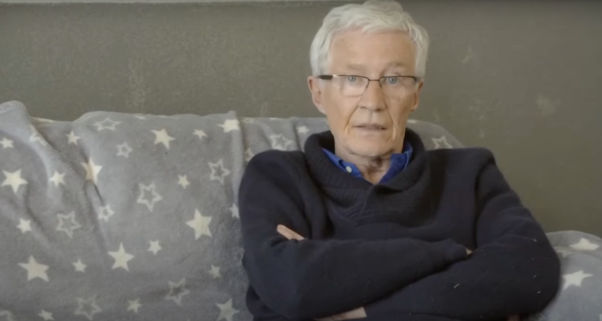 Paul O'Grady sitting with his arms folded