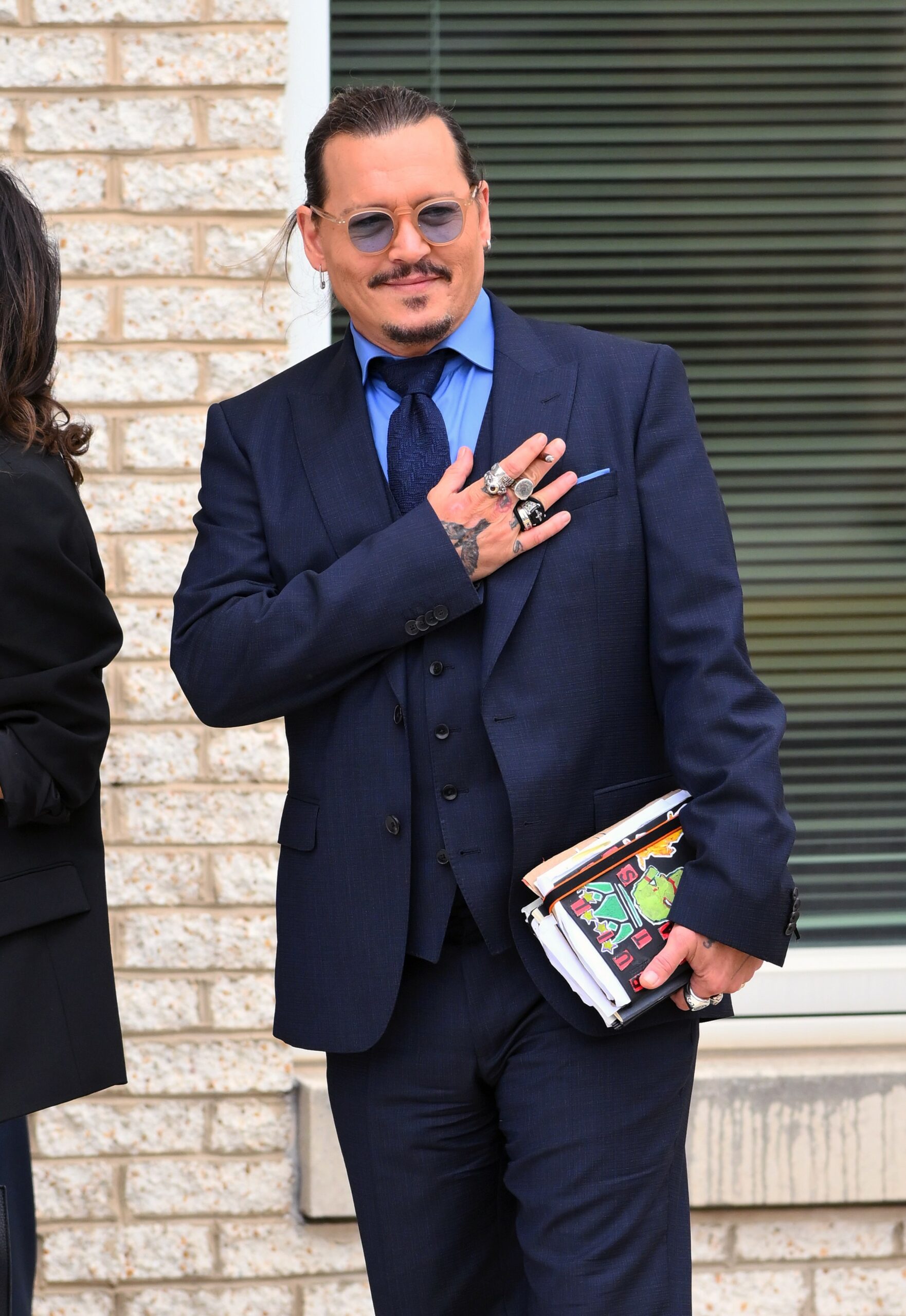 Johnny Depp puts hand on his chest as he leaves court