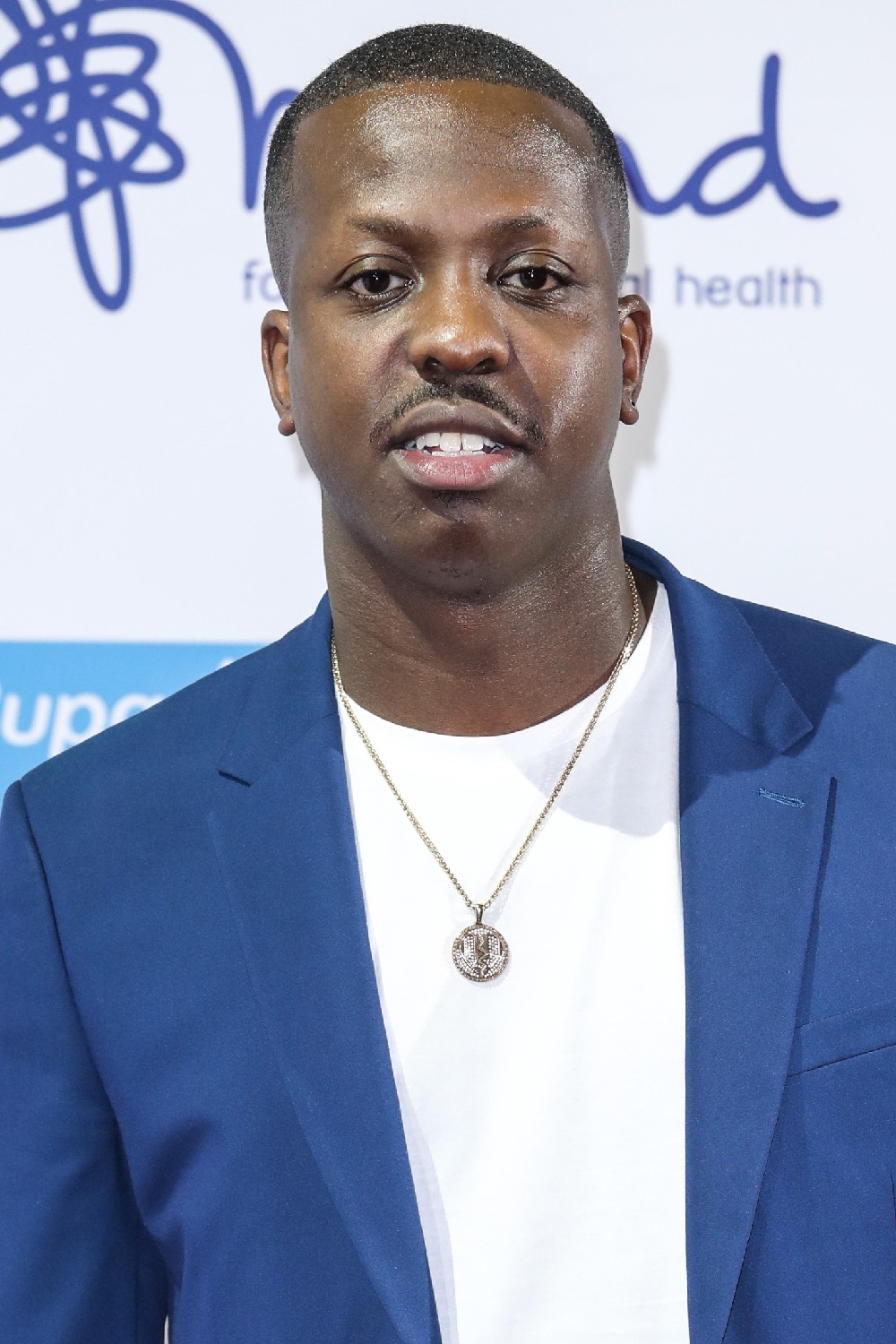 Jamal Edwards looks towards the camera in blue suit