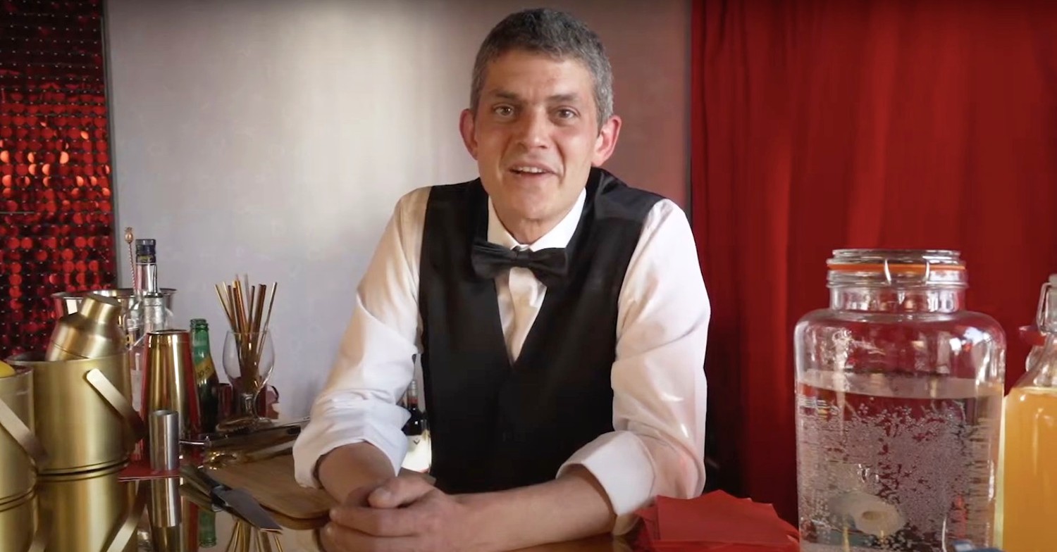 Merlin Griffiths smiling behind a bar