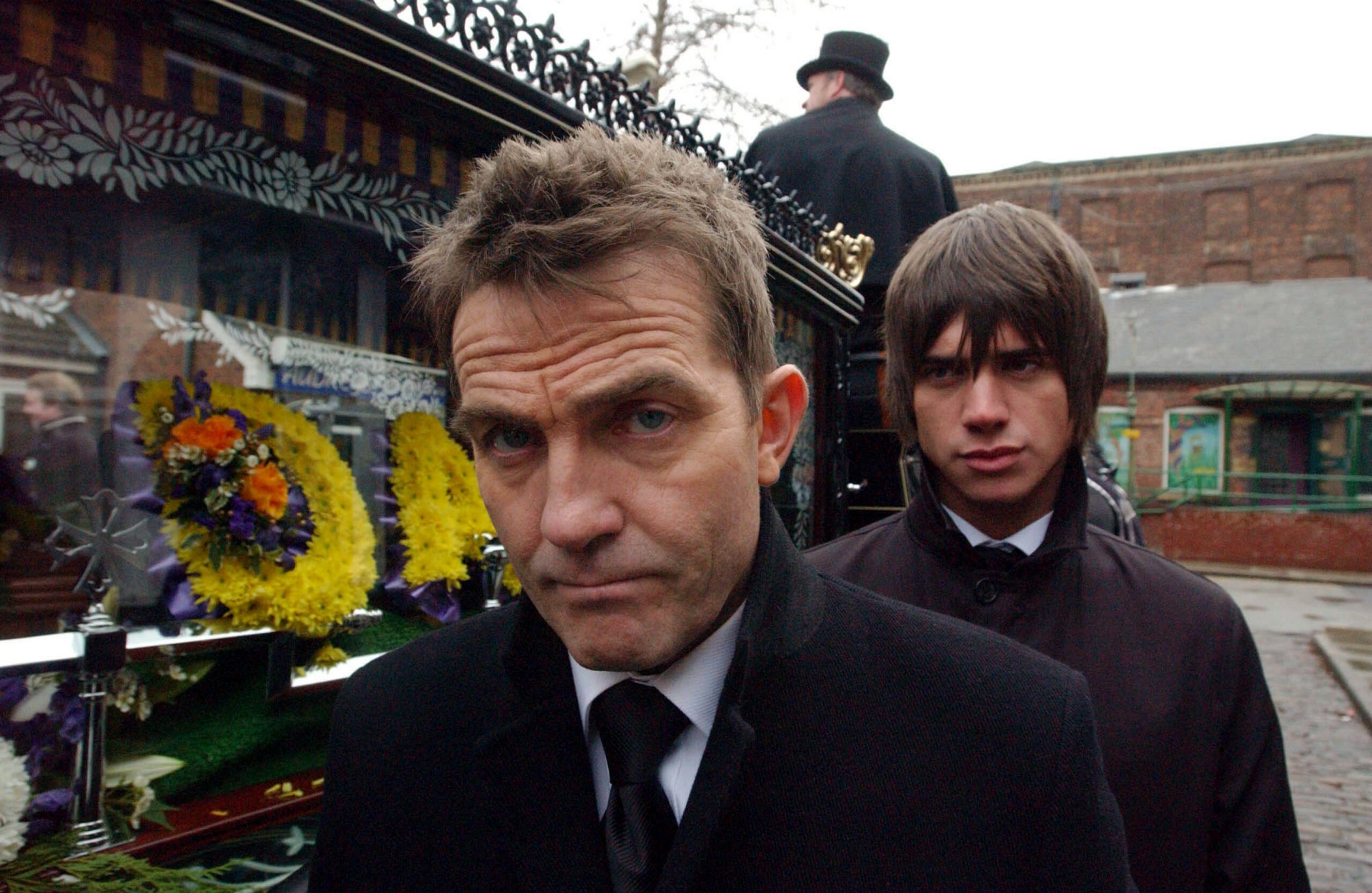 Danny Baldwin looks worried as young Adam Barlow scowls at his back
