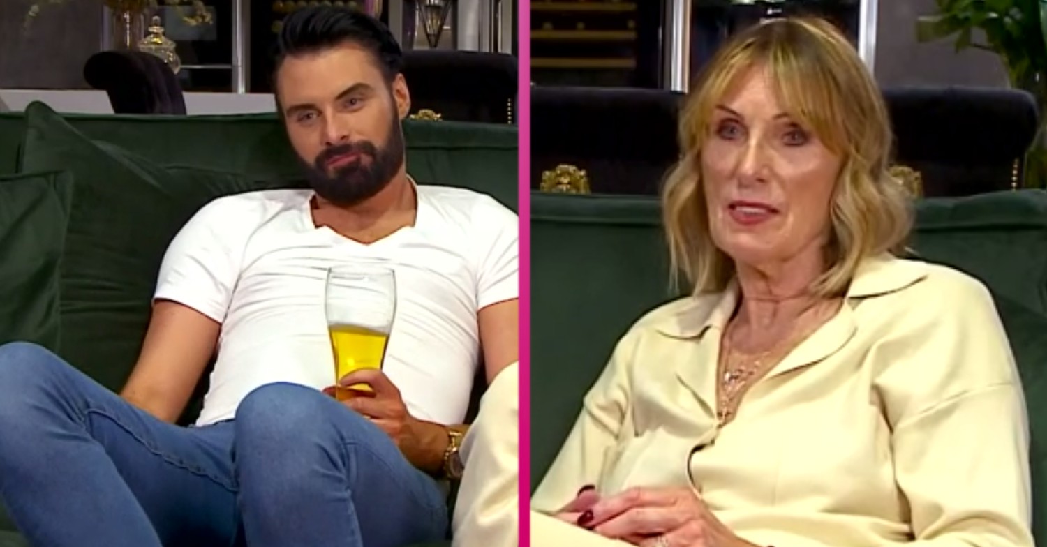 Rylan holds a drink in a glass and his mum Linda watches TV on Celebrity Gogglebox